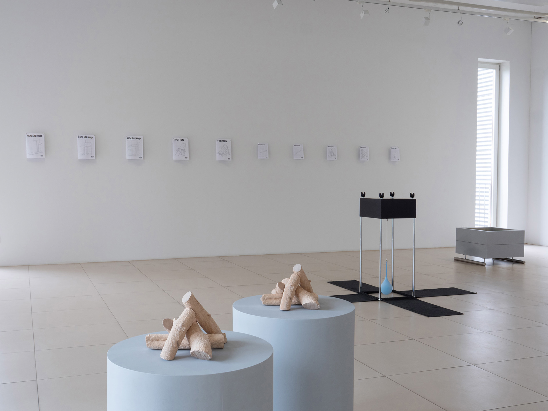 Exhibition view featuring instruction drawings and sculptures.