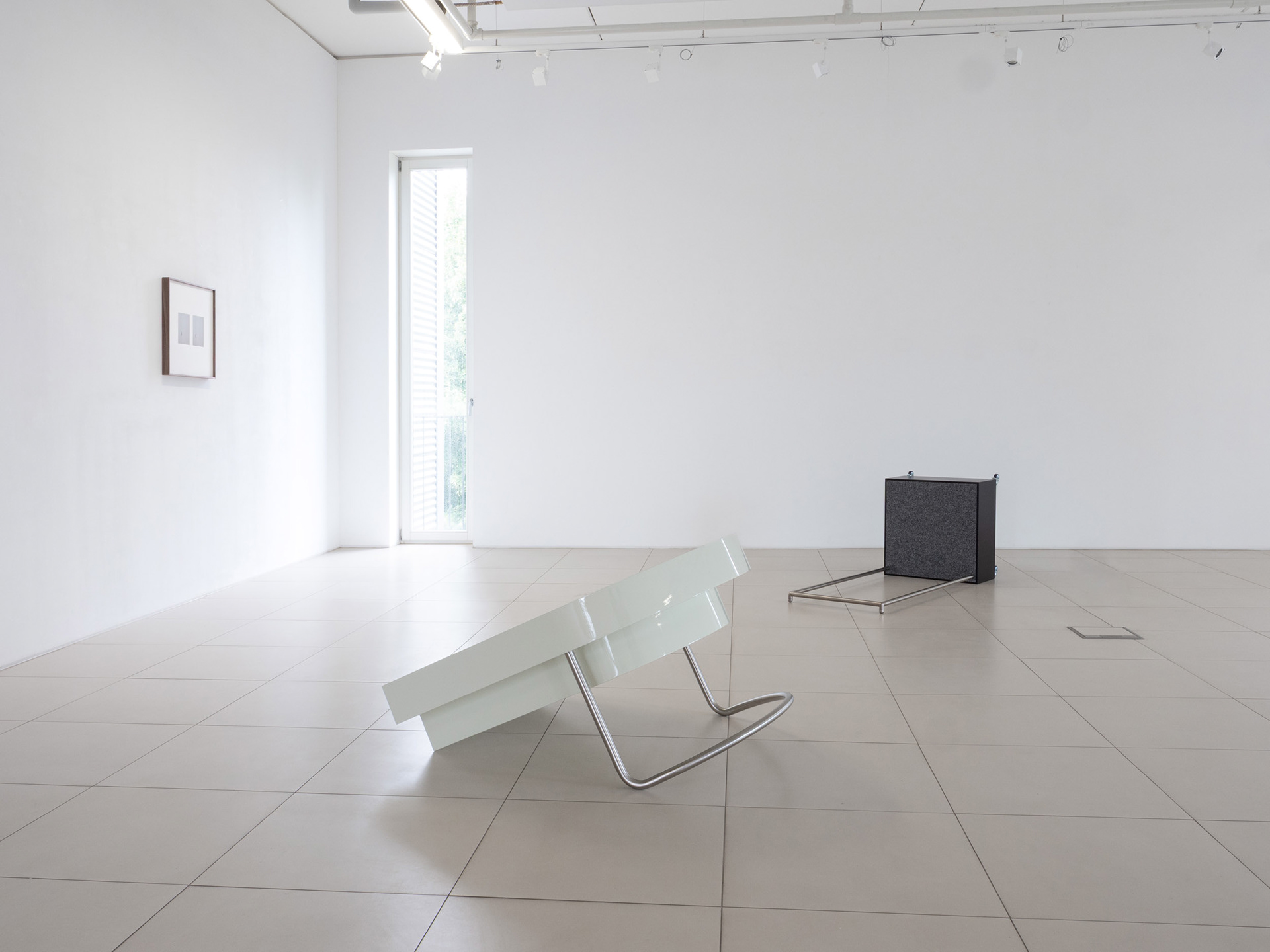 Exhibition view featuring photographic works and sculptures.