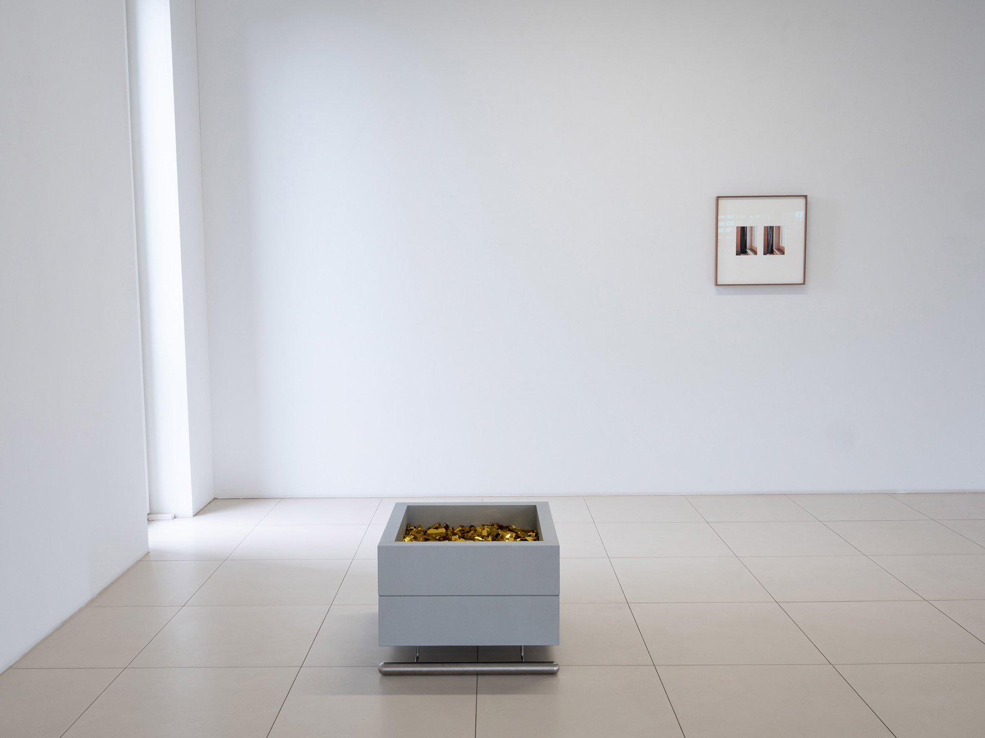 Exhibition view featuring a photographic work and a sculpture.