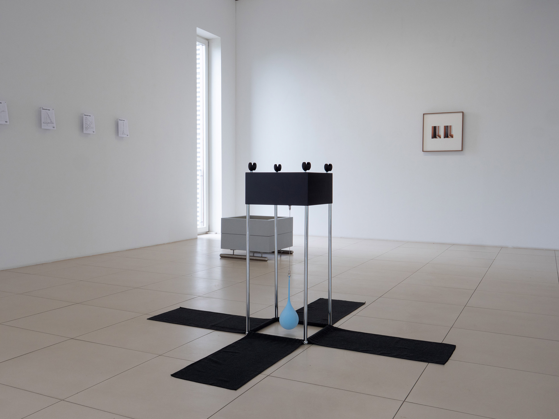 Exhibition view featuring sculptures, furniture instruction drawings and photographic works.