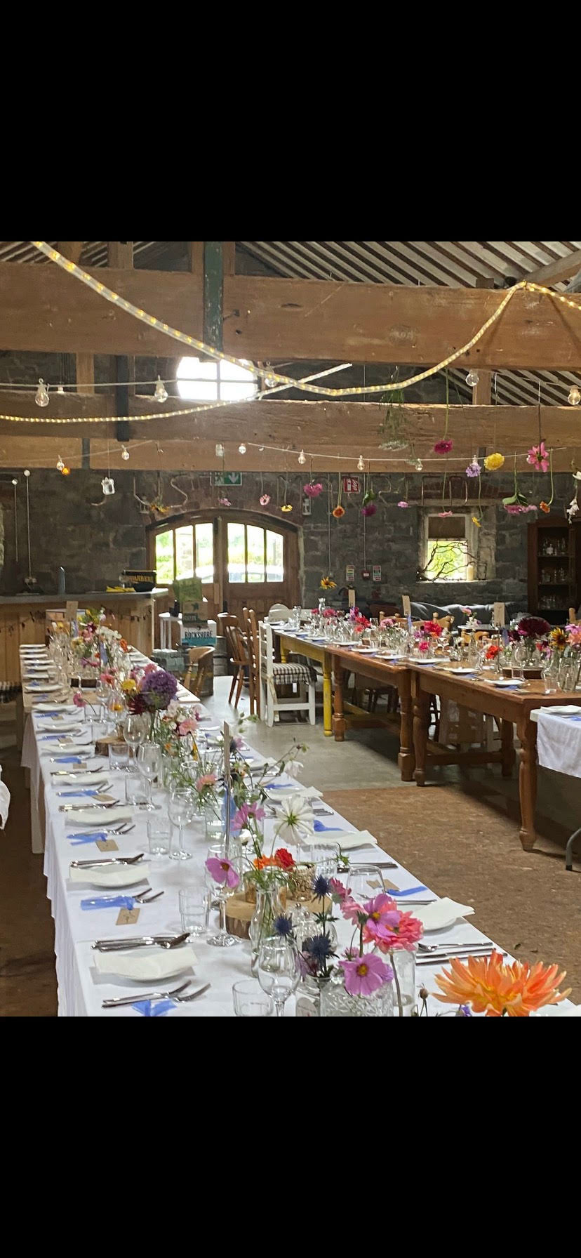 Banquet tables filled with mis match jars, bottles and vintage vases