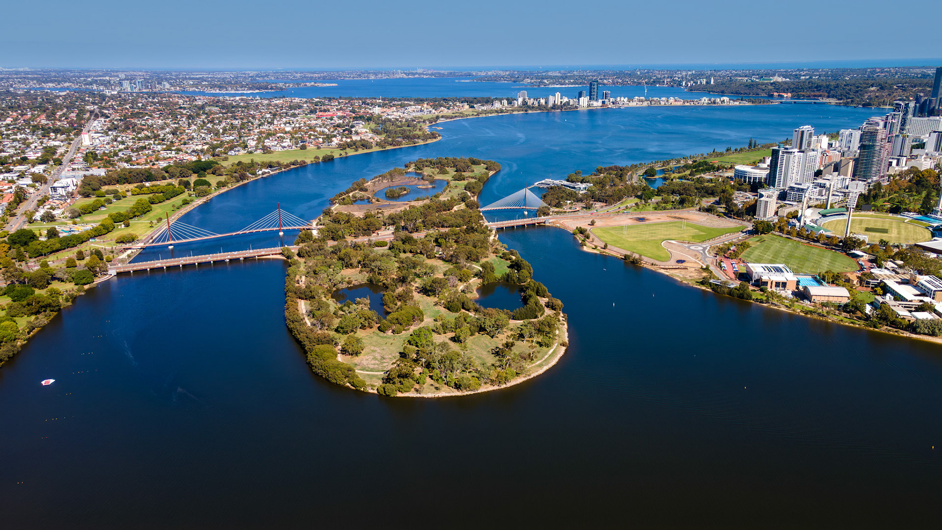 Nestled within the city, this vibrant river park area showcases winding waterways and lush landscapes. People enjoy outdoor activities, taking in the beauty of this serene environment.