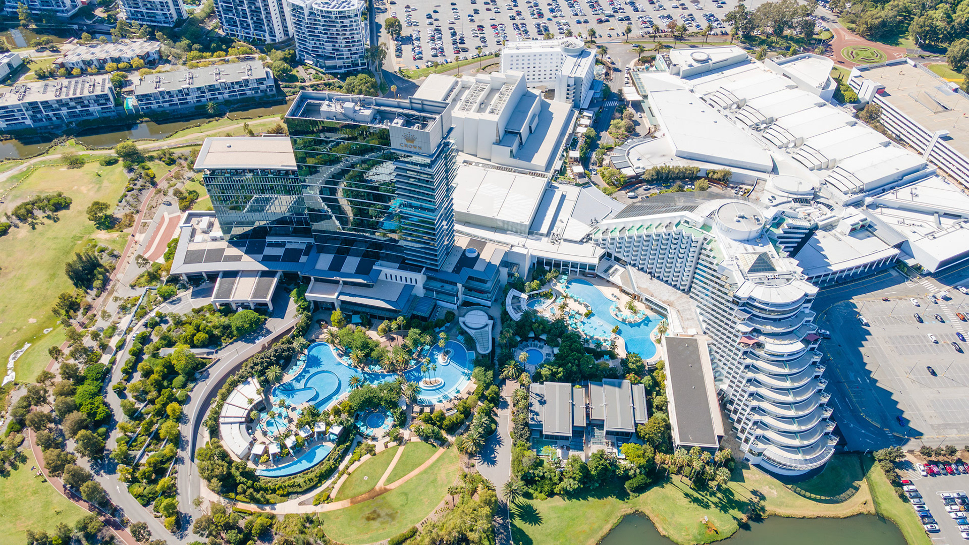 This lively resort showcases a captivating landscape filled with sparkling swimming pools and greenery, perfect for guests enjoying a sunny afternoon. Families relax and have fun.