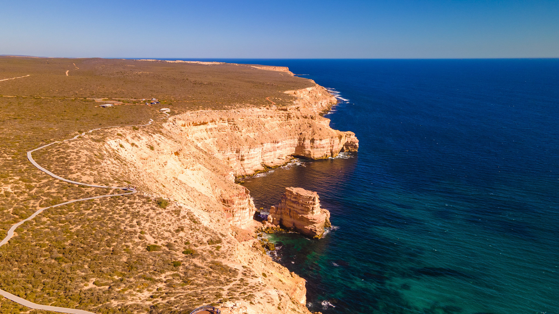 Experience the breathtaking beauty of a rugged cliff and ocean landscape. This serene aerial view captures nature's stunning formations.