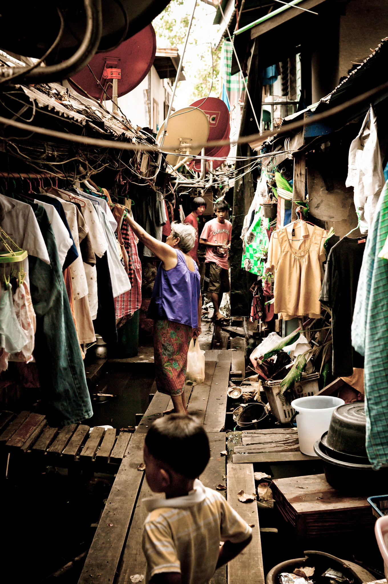 Life in a hidden alleyway above the water of the Chao Phraya river, 150m from the Grand Palace.