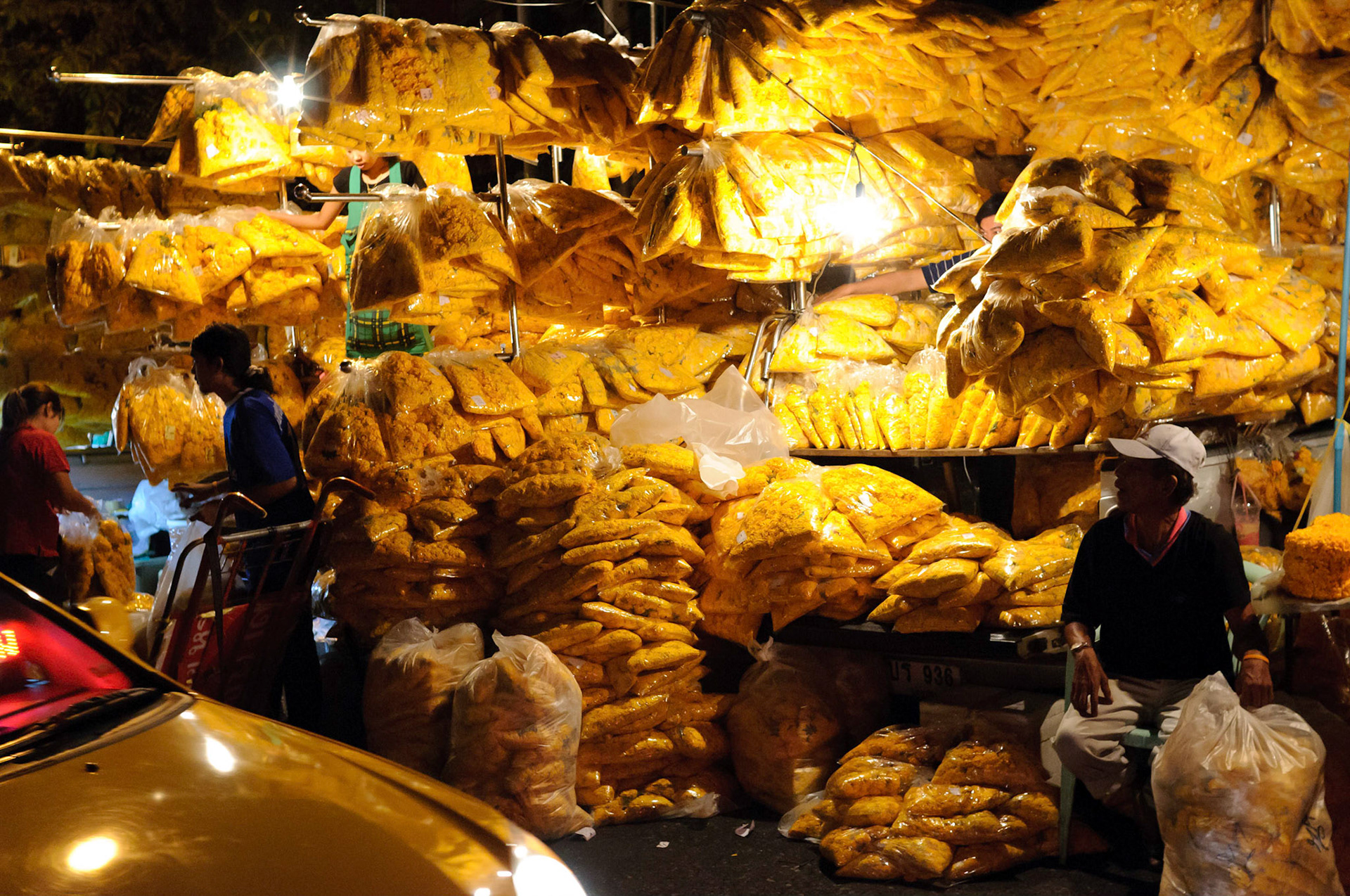 The backs of two pickup trucks, absolutely loaded with flowers.