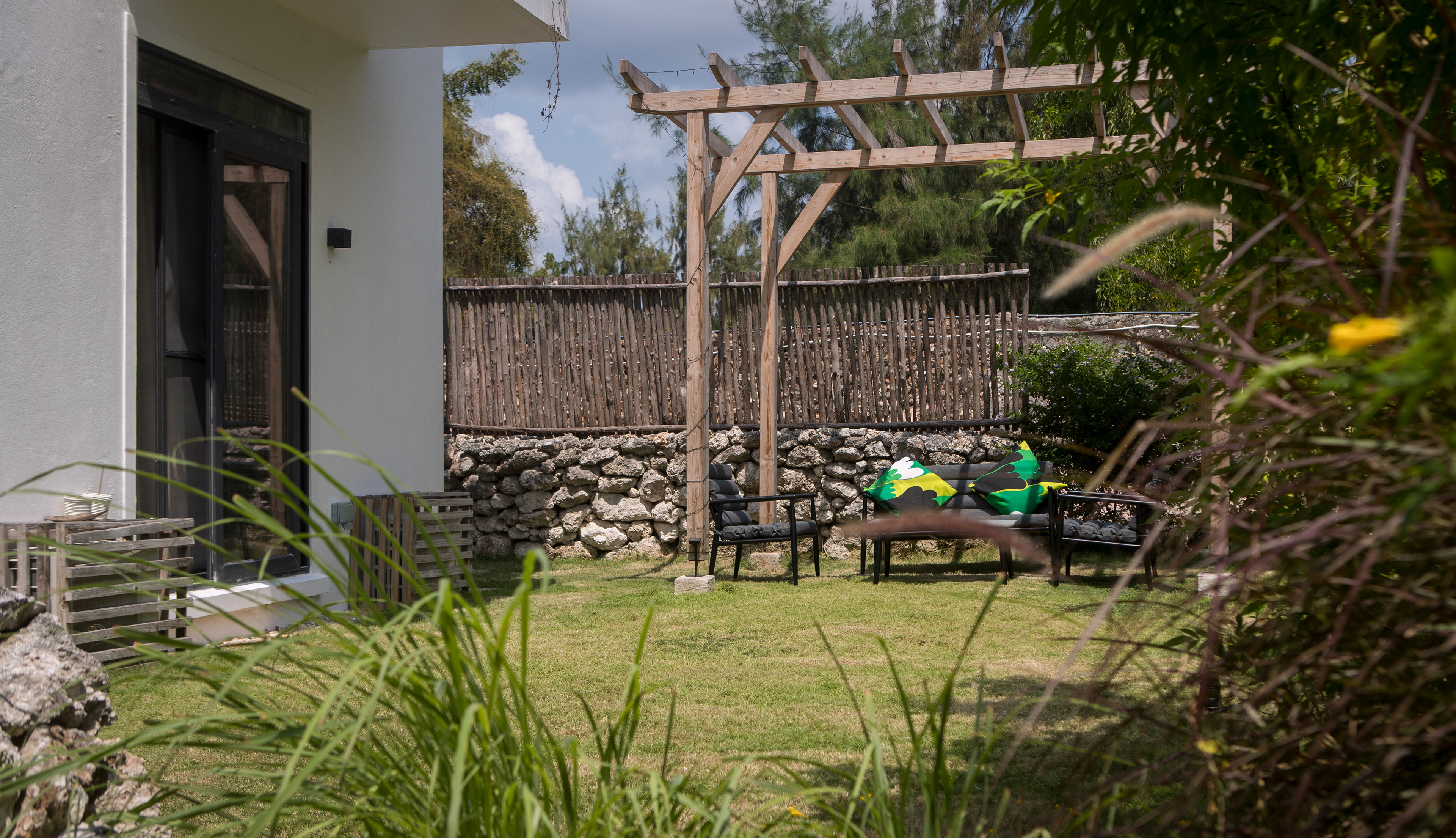 The outdoor garden has a cozy seating area and a pathway that leads to the lagoon swimming pool