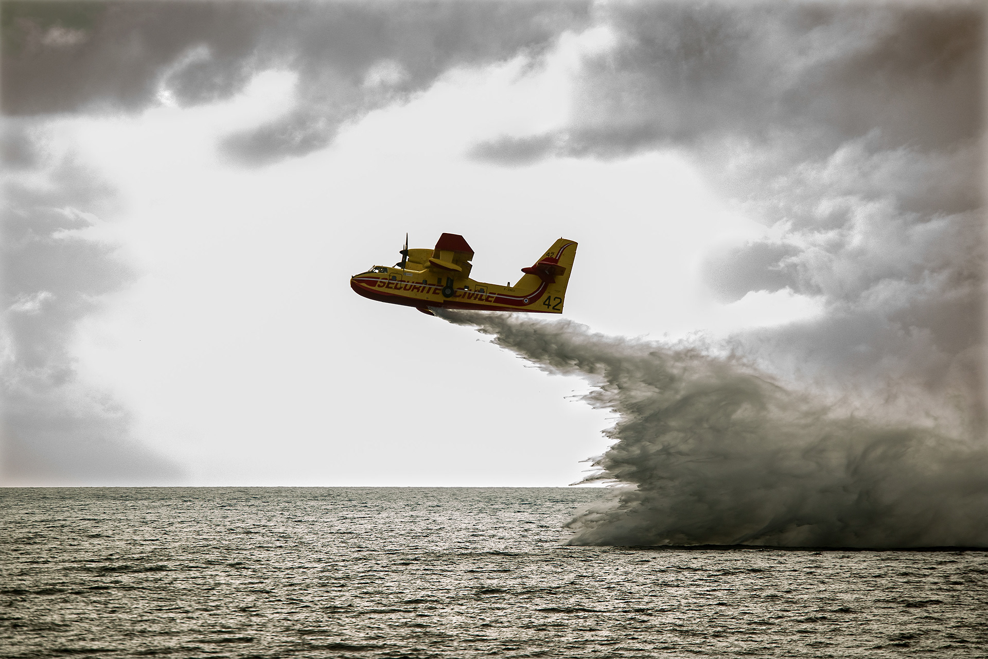 Canadair, avion bombardier d'eau en plein exercice par mauvais temps.