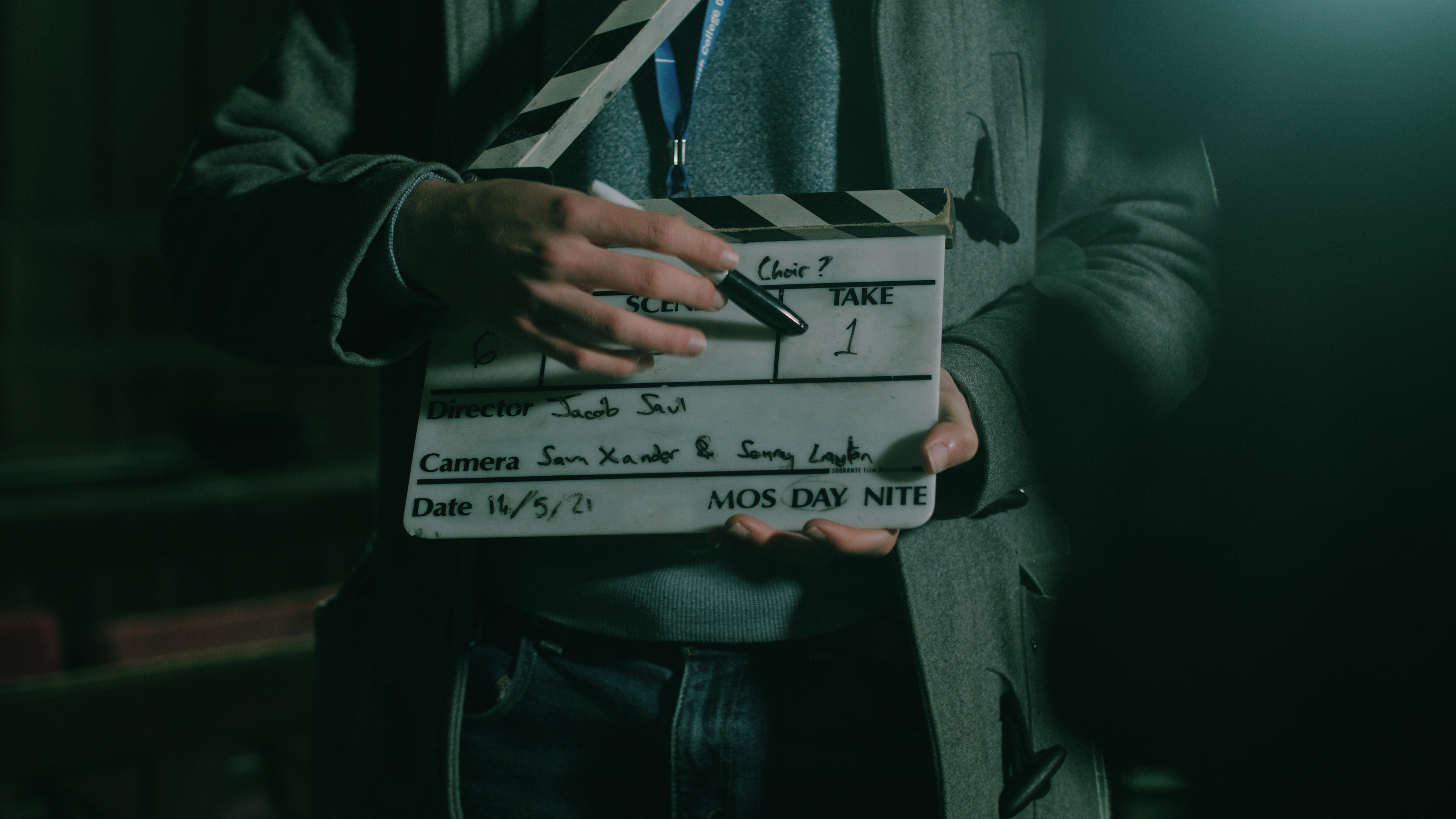 The director holds a slate, pointing at the take number.