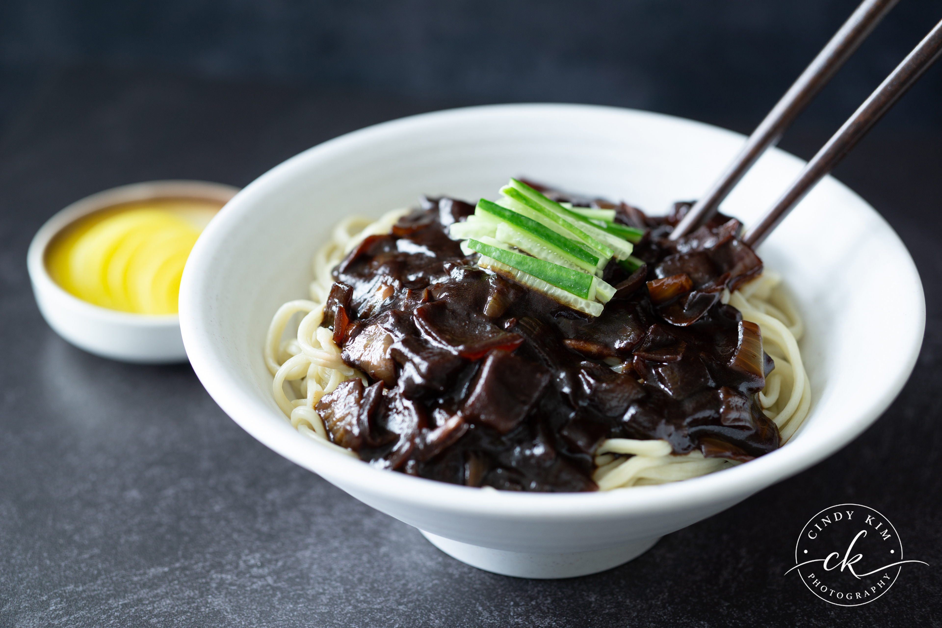 Traditional Korean Jajangmyeon Black Bean Noodles Close-Up with Cucumber Garnish