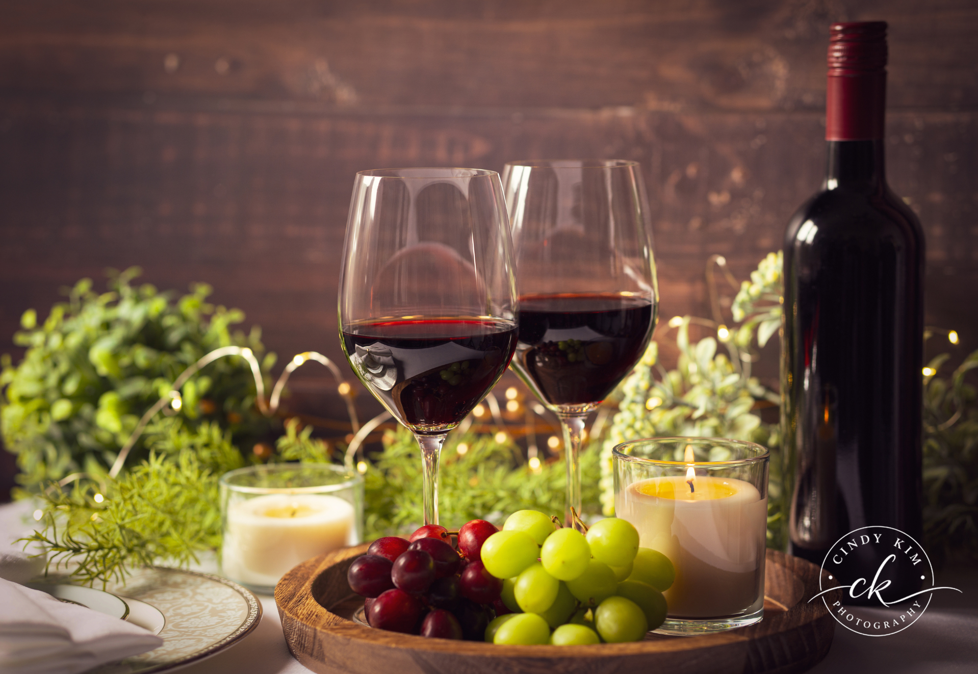 Red Wine Glasses, Fresh Grapes and Candle on Rustic Wood Tray Still Life