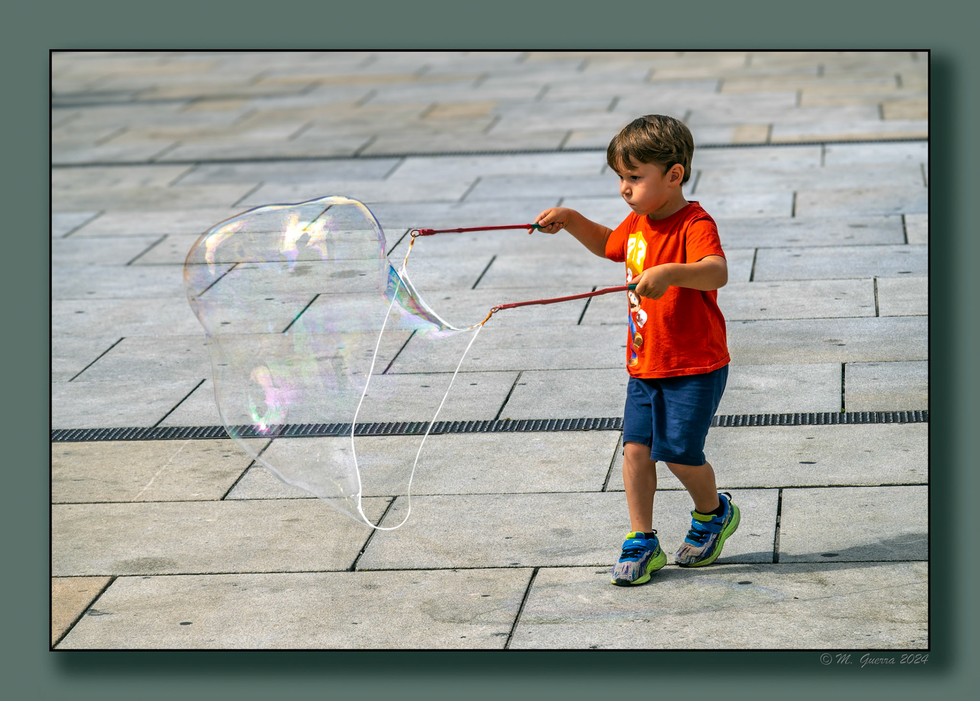 Niño jugando a hacer pompas de jabón en la Plaza de la Virgen Blanca en Vitoria