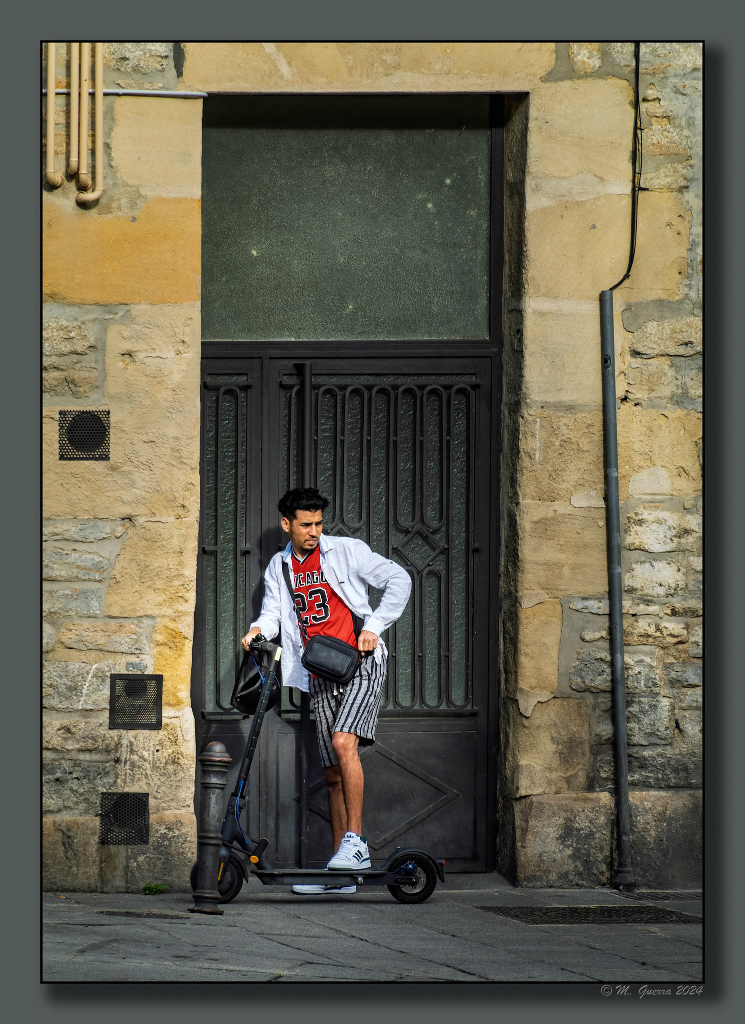 Chico con patinete en una puerta de una casa en Vitoria