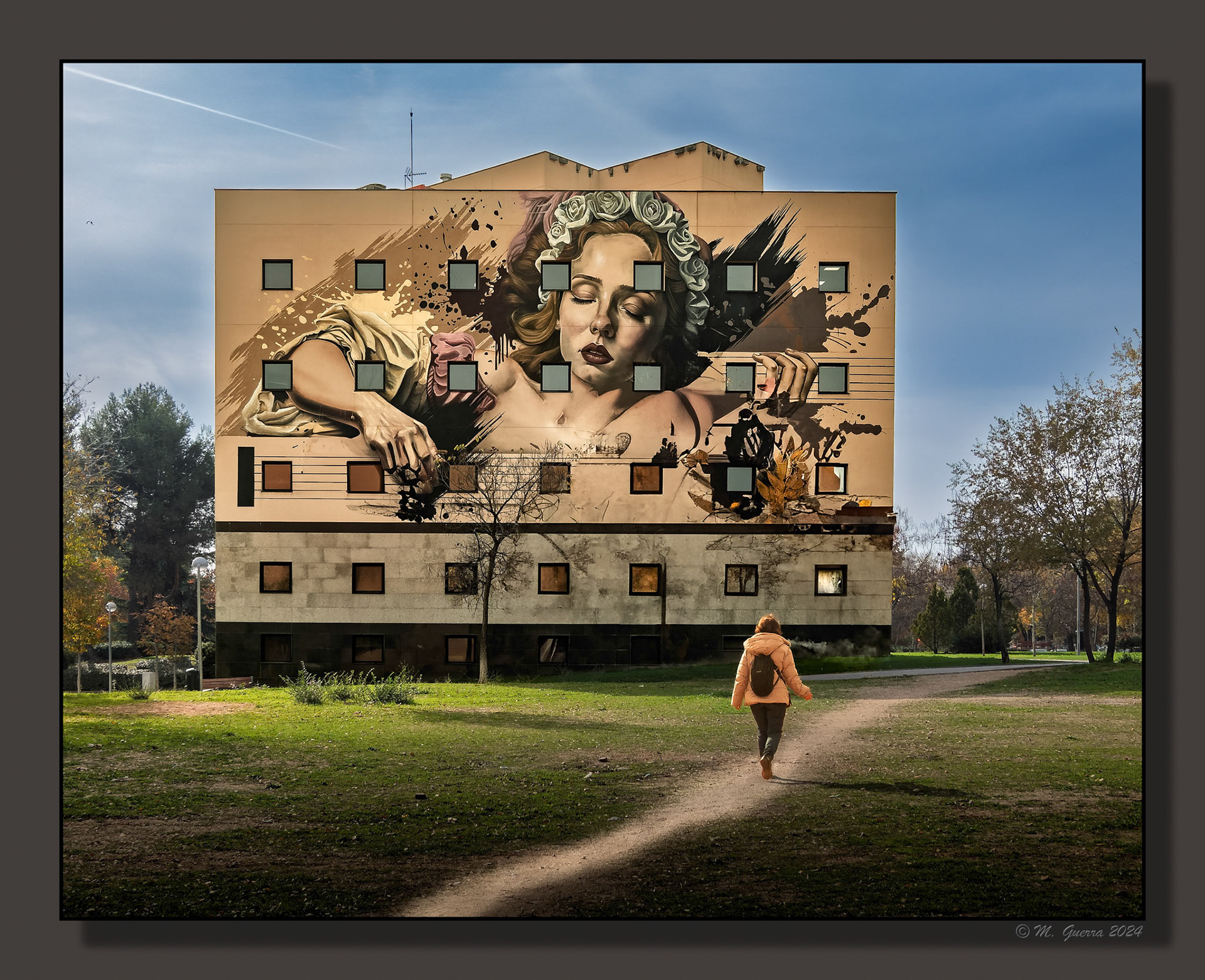 Casa con mural pintado en la fachada al lado de un parque en Moratalaz