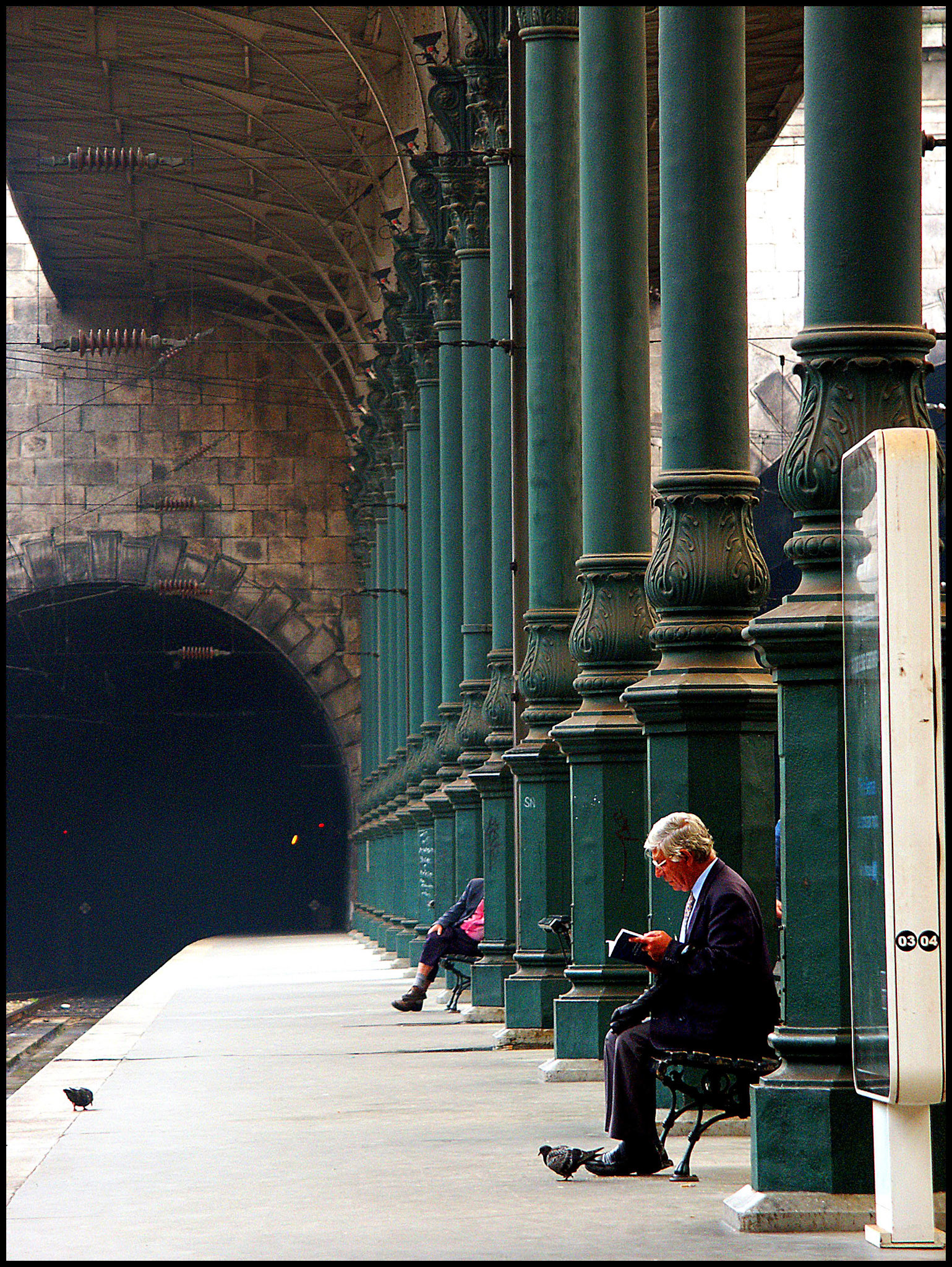 Una persona leyendo en la estación de trenes de Oporto. Ampliar. 100ASA