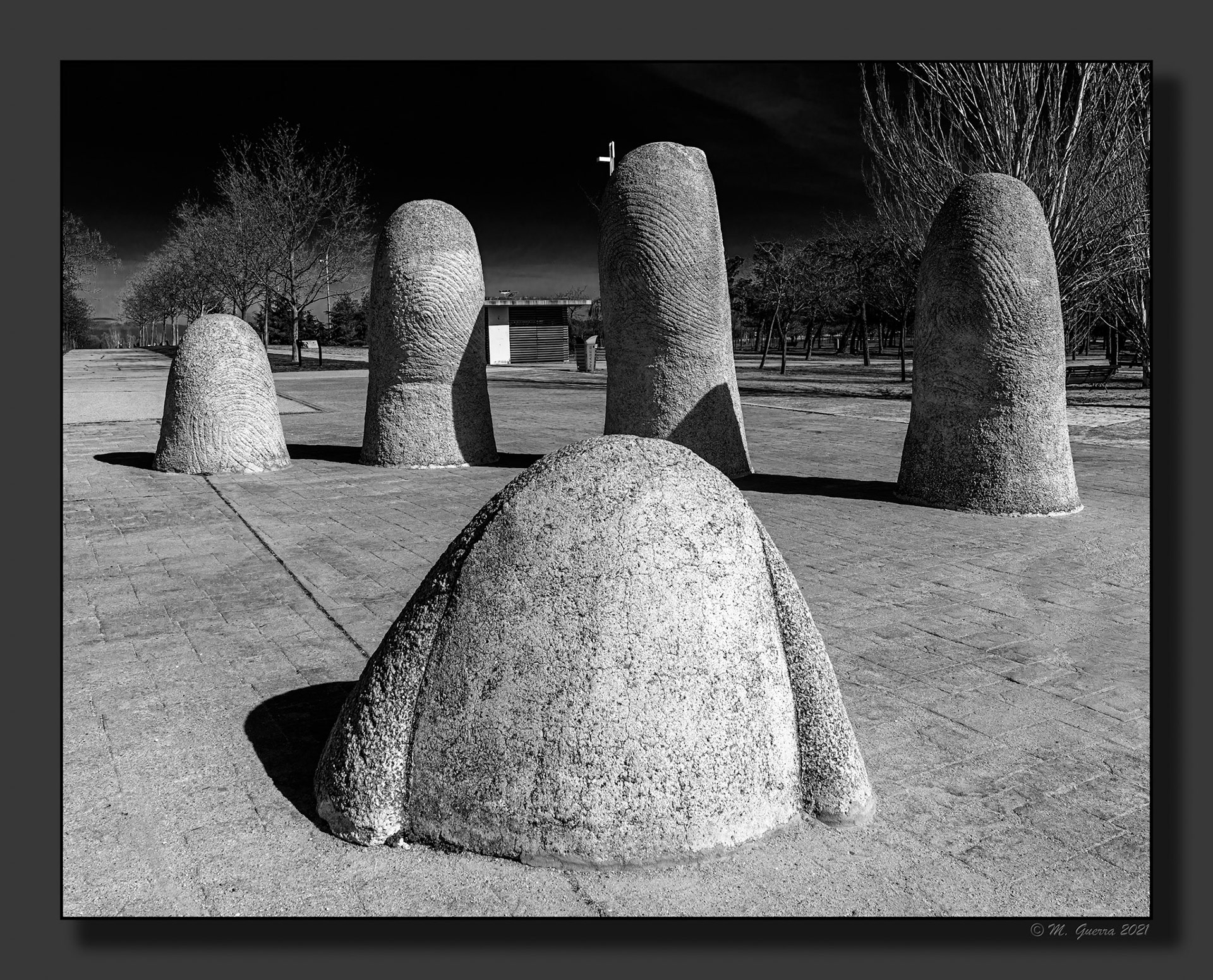 Escultura con forma de unos dedos saliendo del suelo en el parque de Juan Carlos I
