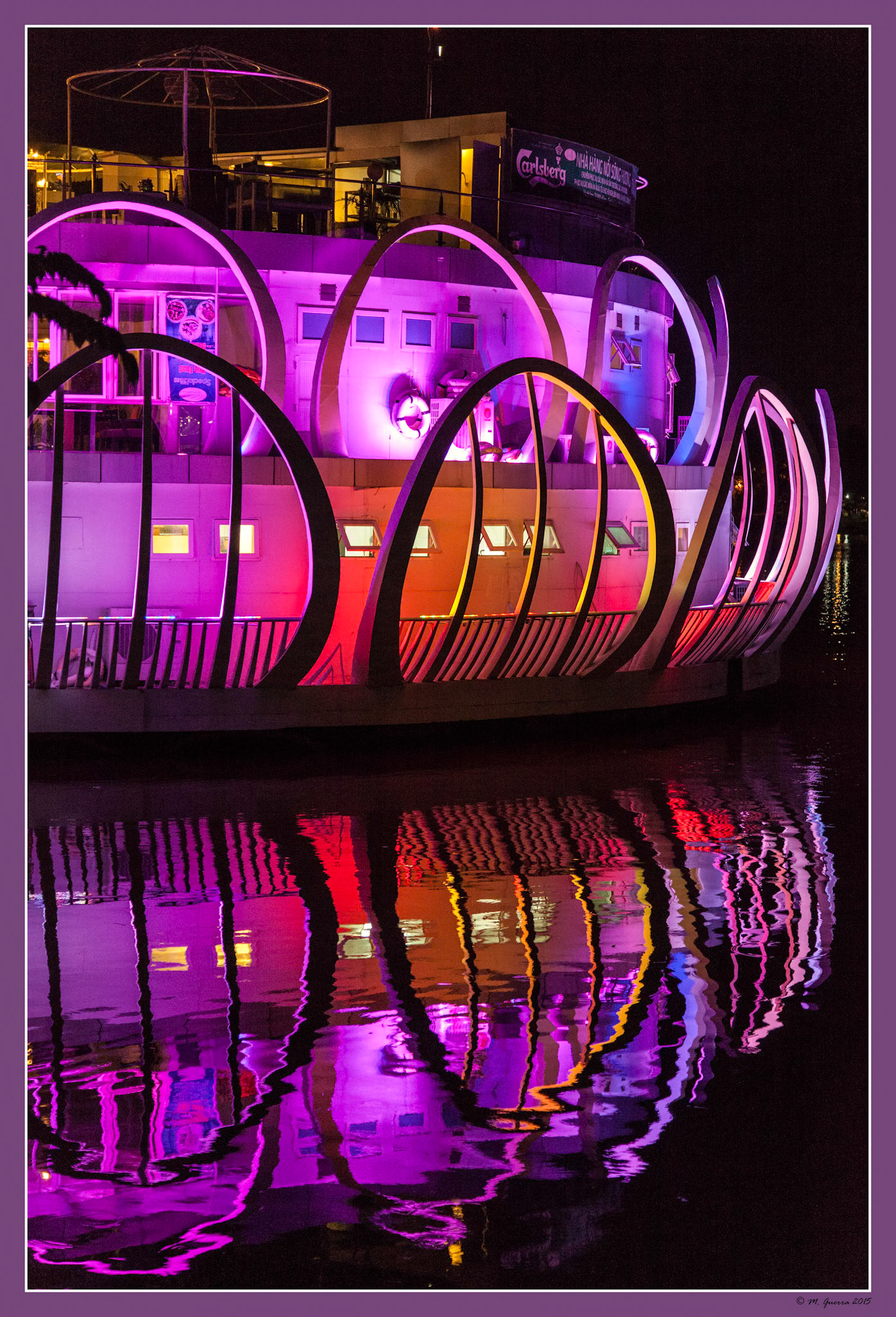 Restaurante acuático sobre el río en Hue iluminado de noche. Ampliar