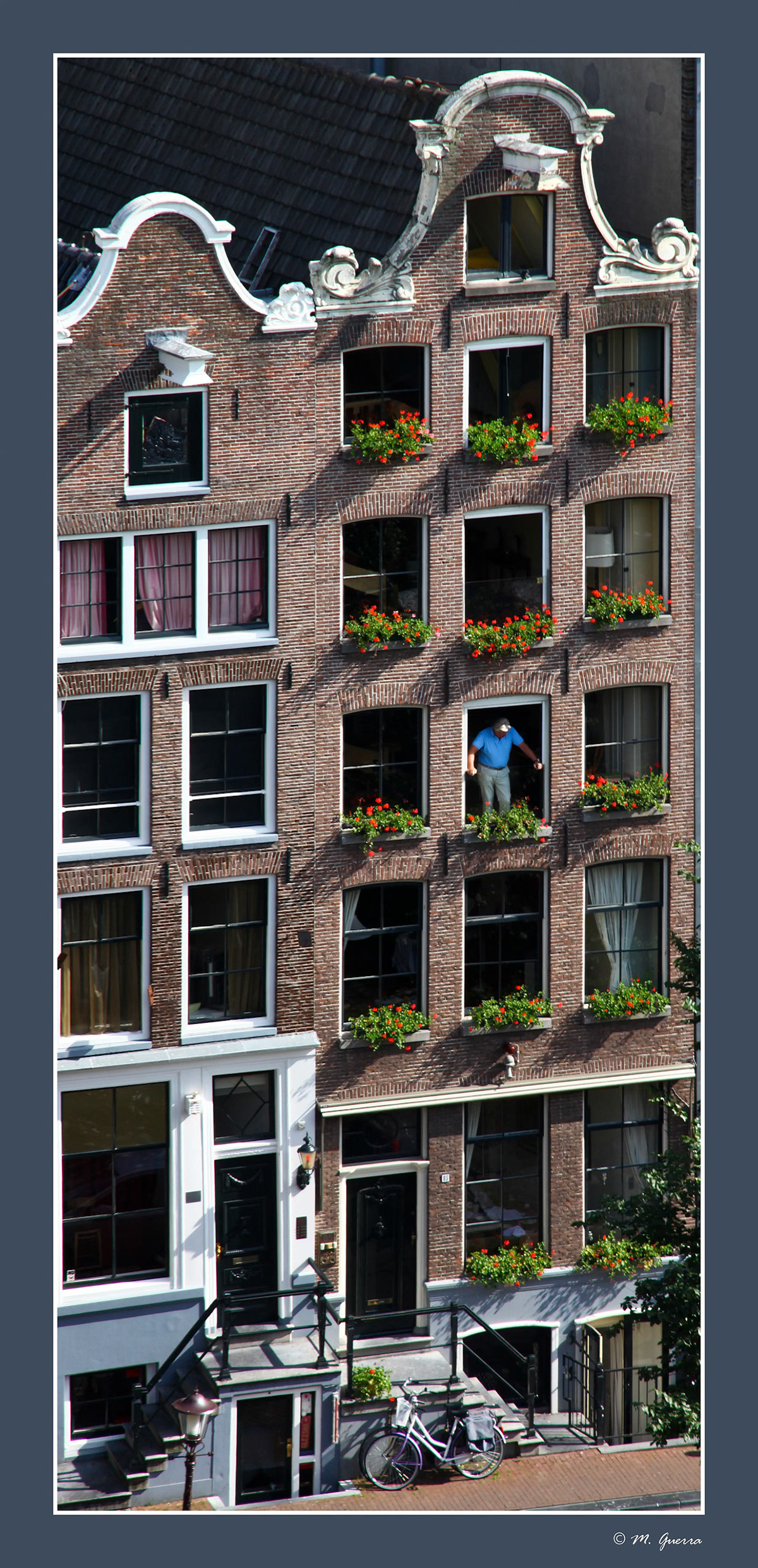 Un hombre mirando al vacío desde una casa de Amsterdam. Ampliar
