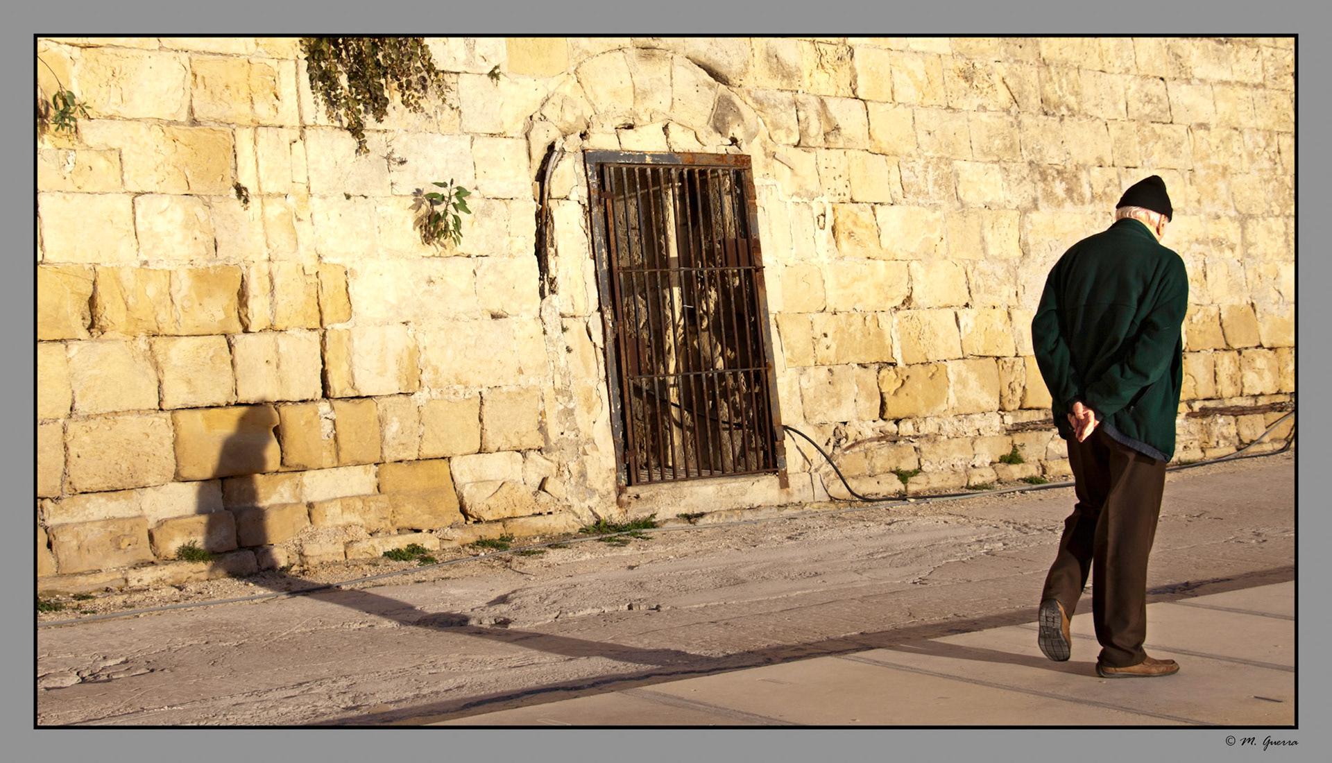 Anciano paseando al lado de una muralla del fuerte de Sant Ángelo en las Tres Ciudades de Malta. Ampliar