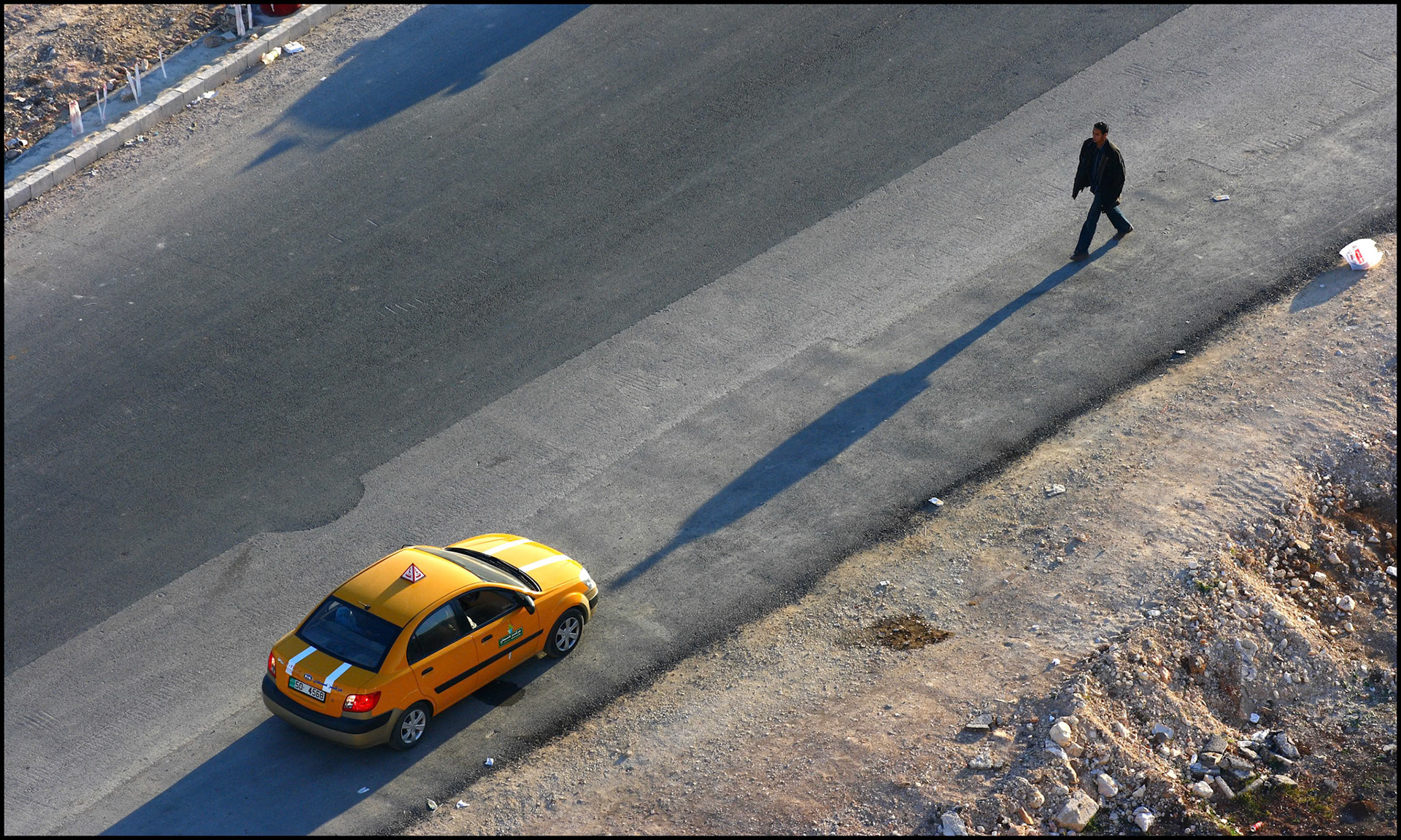 Un jordano paseando al lado de un taxi en Amman. Ampliar. 100ASA