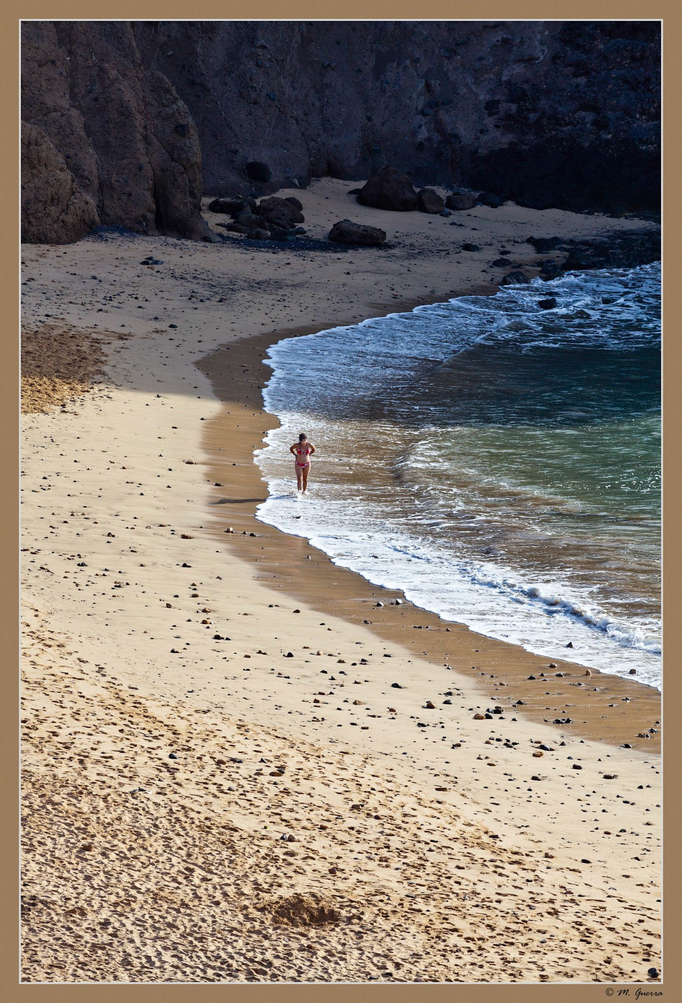 Una chica en La punta y la playa de El Papagayo en Lanzarote. Ampliar
