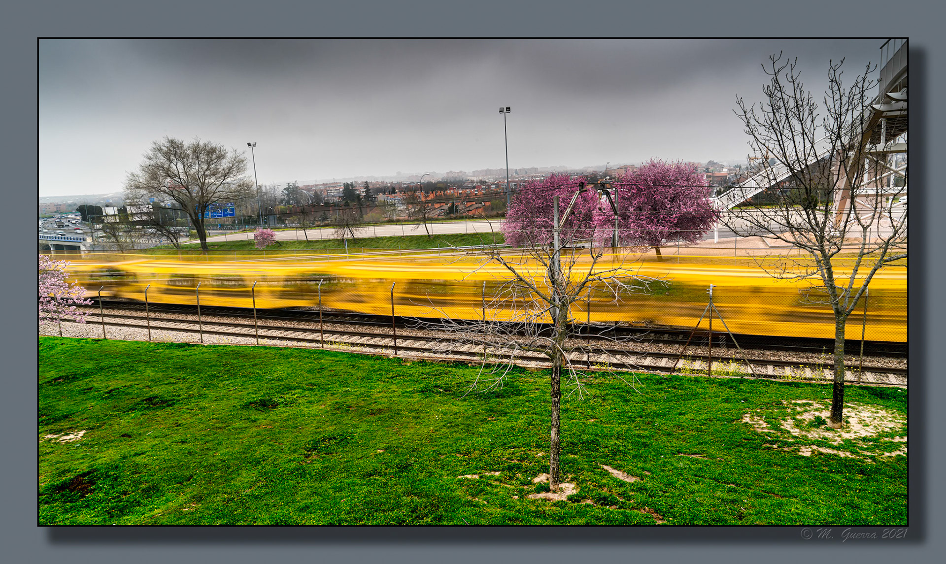 Vías de tren y trenes pasando al lado del parque de Juan Carlos I