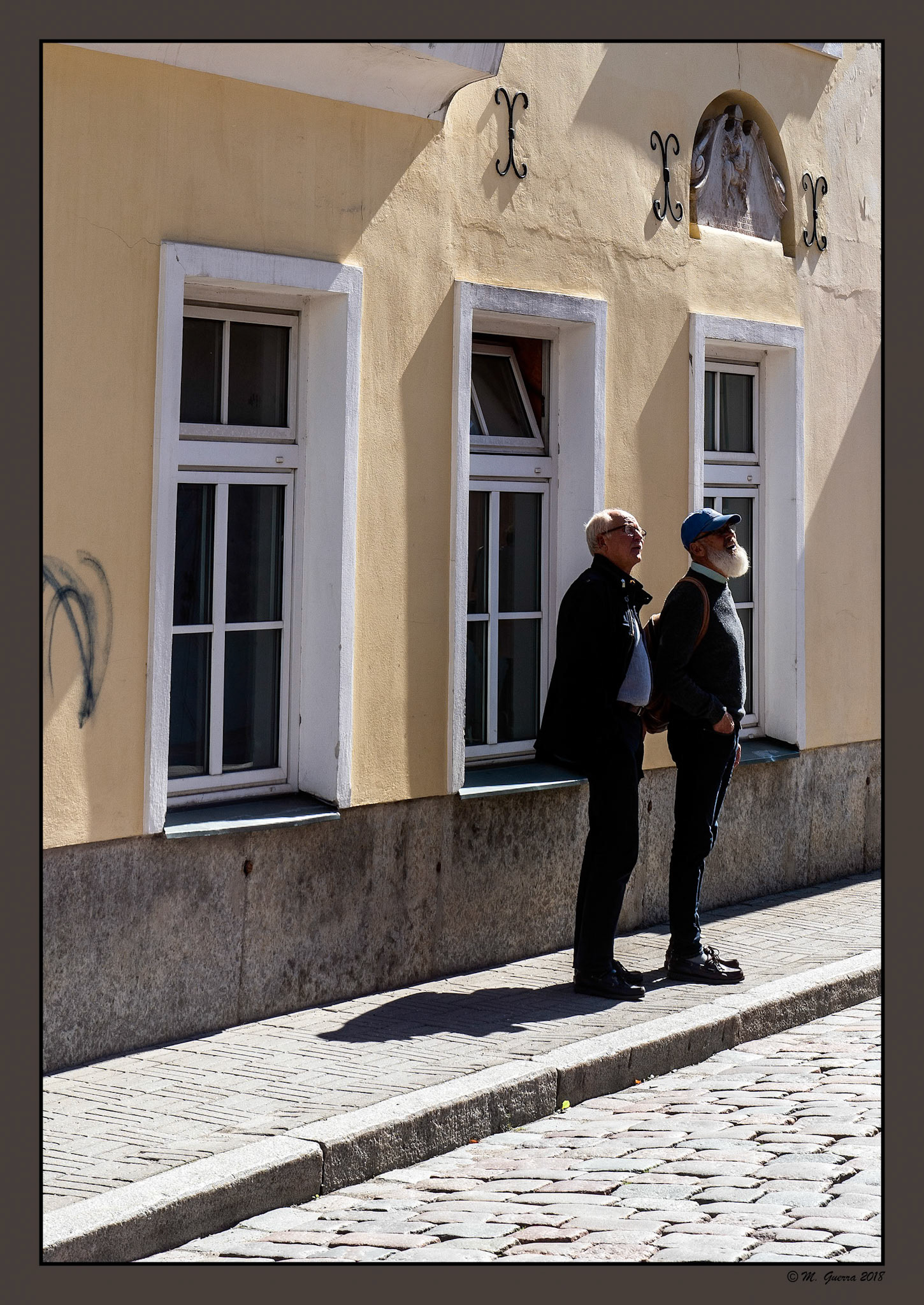 Dos hombres, uno de ellos con barba blanca, en una calle de Tallin. Ampliar. 100ASA