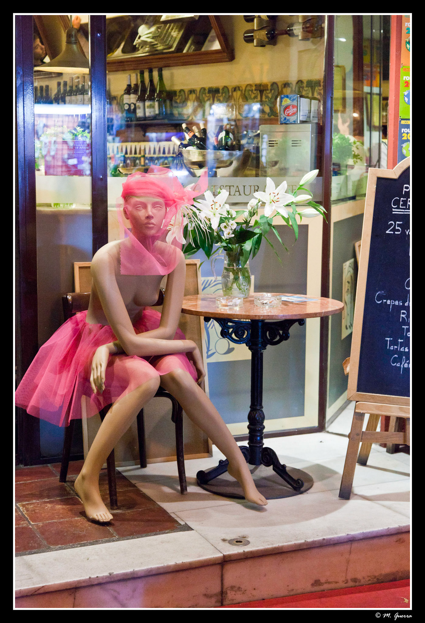 Maniquí sentada en una mesa de un bar en el barrio de las Letras de Madrid. Ampliar