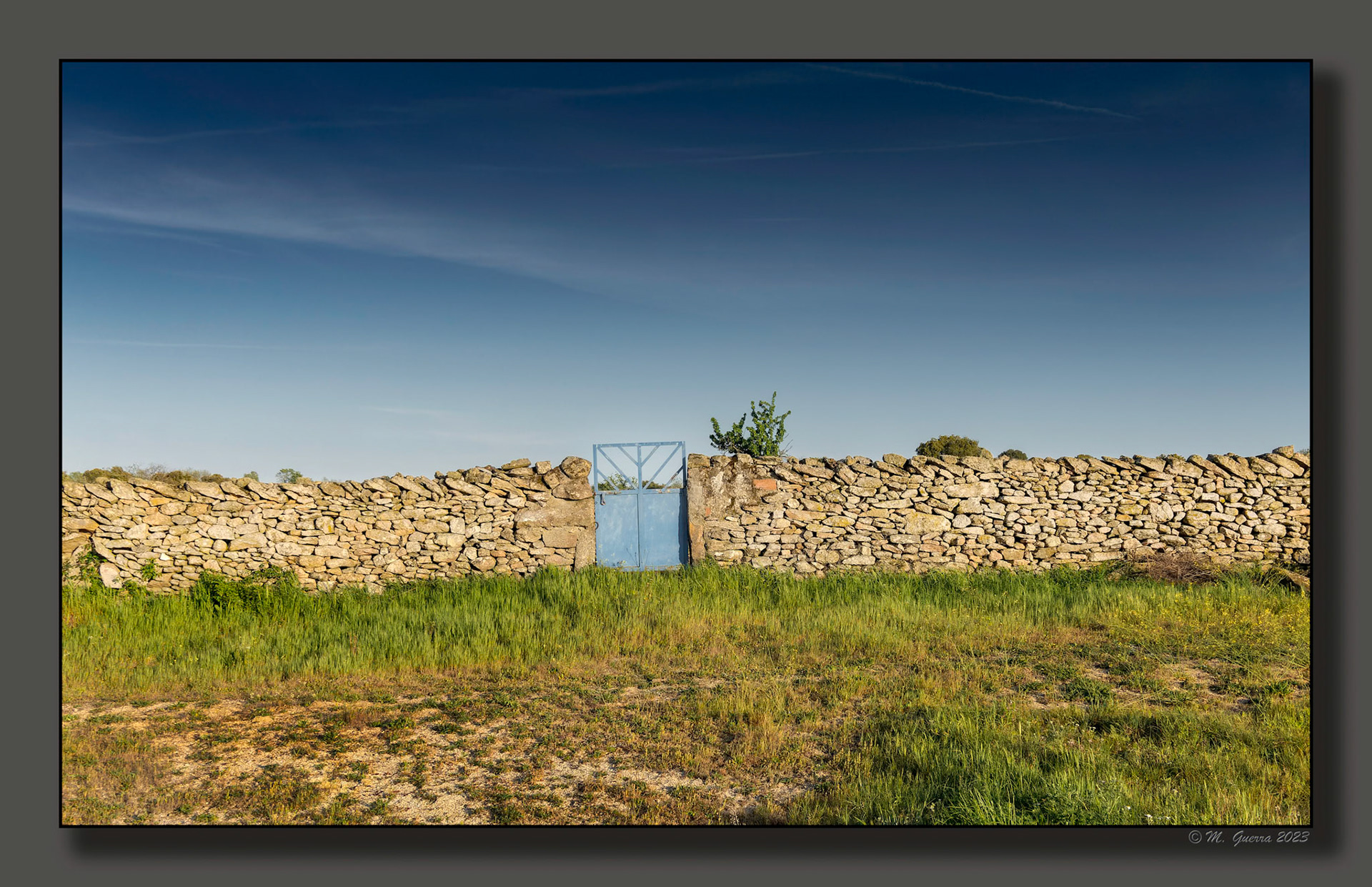 Pared con puerta azul en Peñagorda. 100ASA