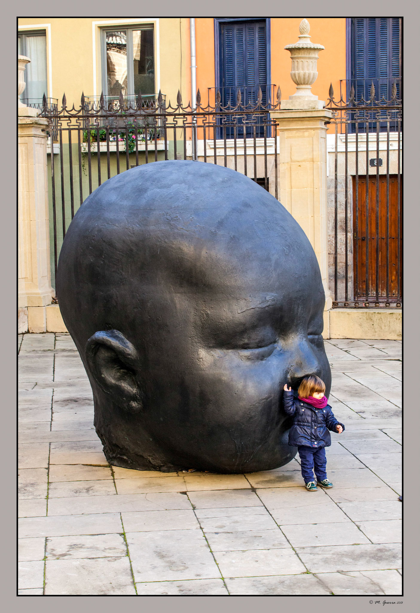 Un niño al lado de la estatua de la sobrina de Antonio López en la Catedral de Pamplona. Ampliar