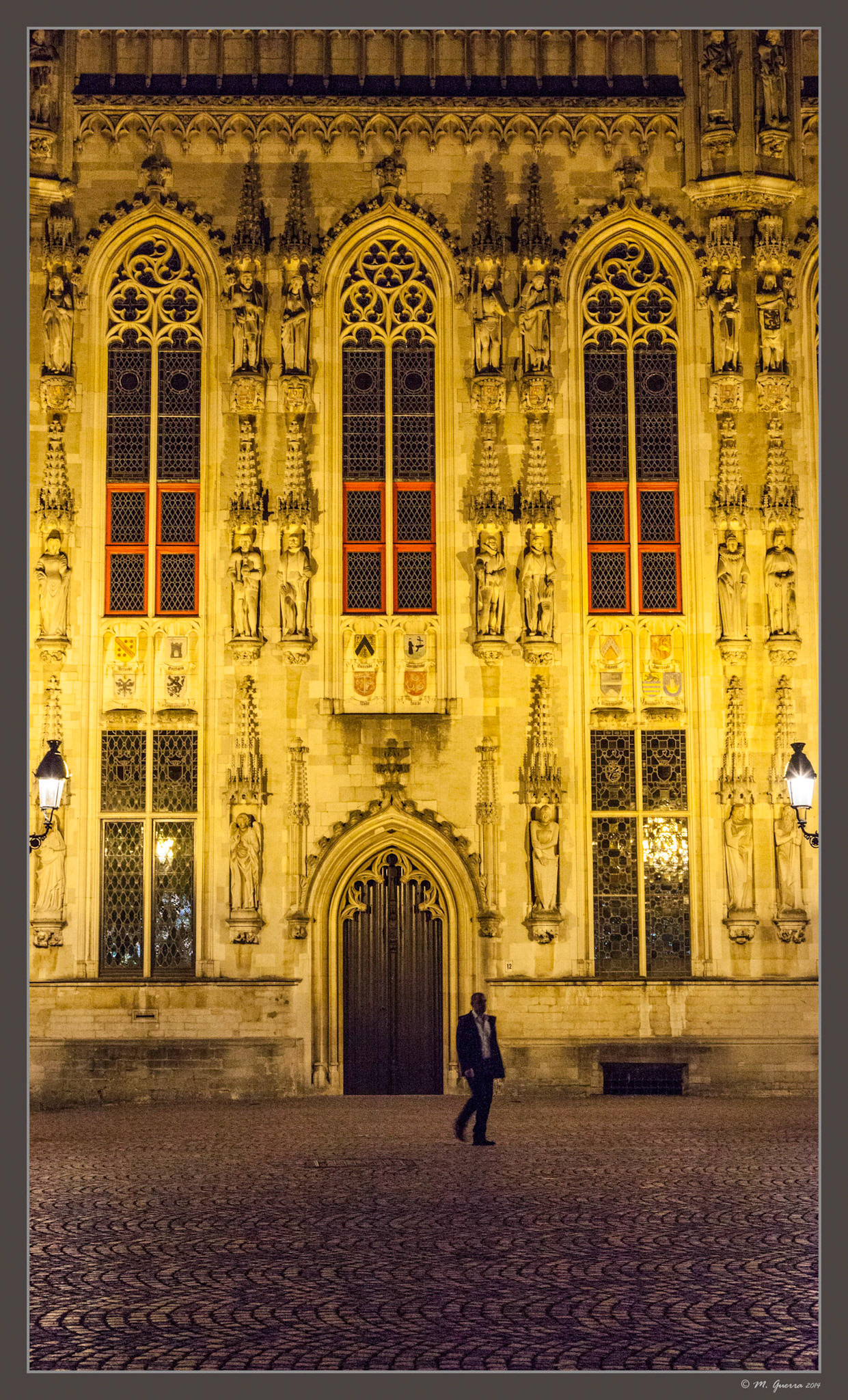 Plaza iluminada de noche en Brujas. Ampliar