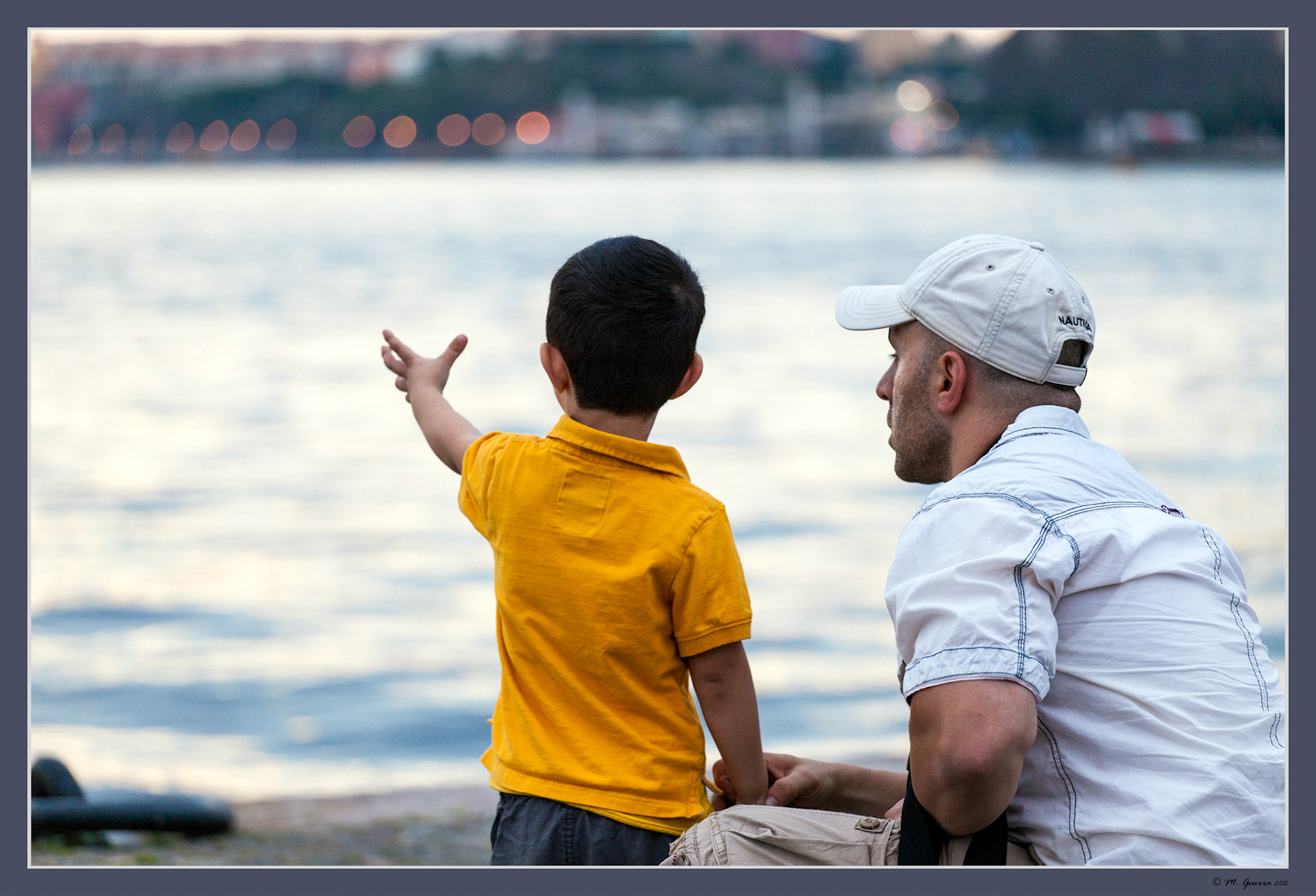 Un padre con su hijo mirando la luz del atardecer en Gamla Stan en Estocolmo. Ampliar