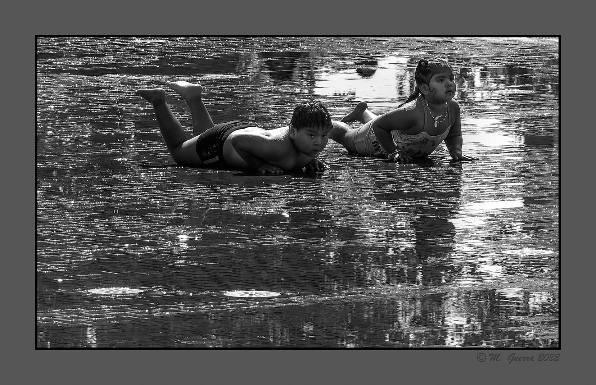 Grupo de niños jugando con las fuentes de chorros y agua pulverizada en Madrid Río
