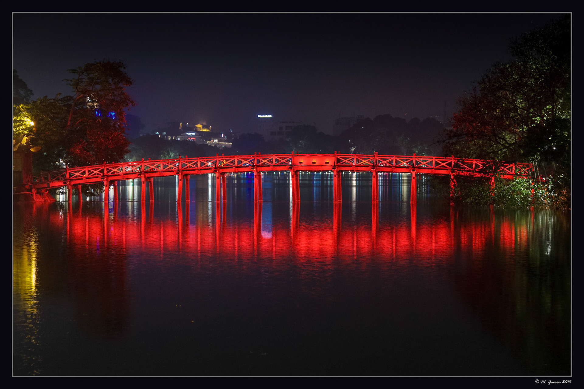 El puente iluminado en rojo en el centro del lago en el parque de Hanoi. Ampliar. 100ASA