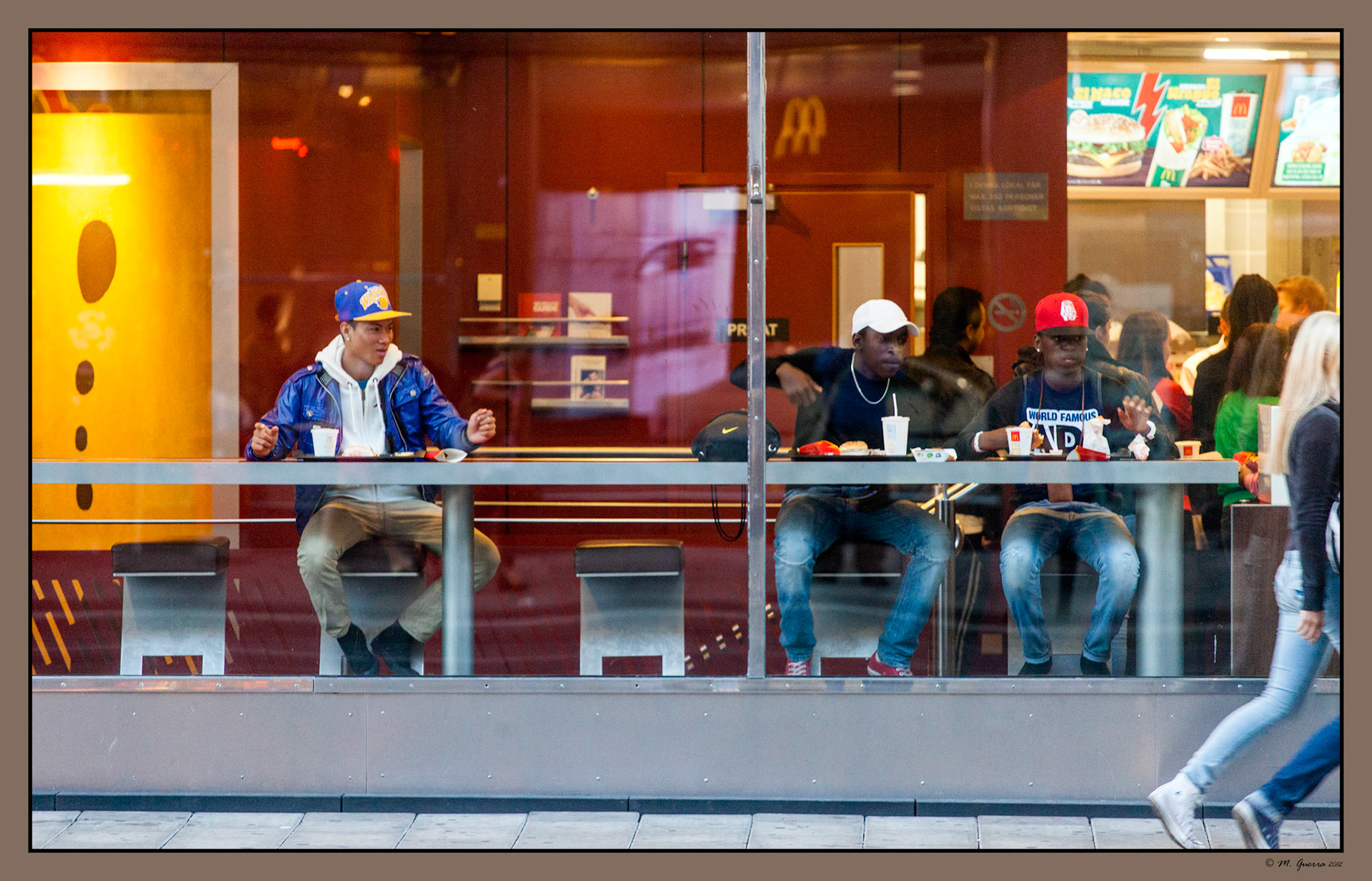 Inmigrantes mirando unas chicas desde un McDonalds de Hanmgatan en Estocolmo. Ampliar