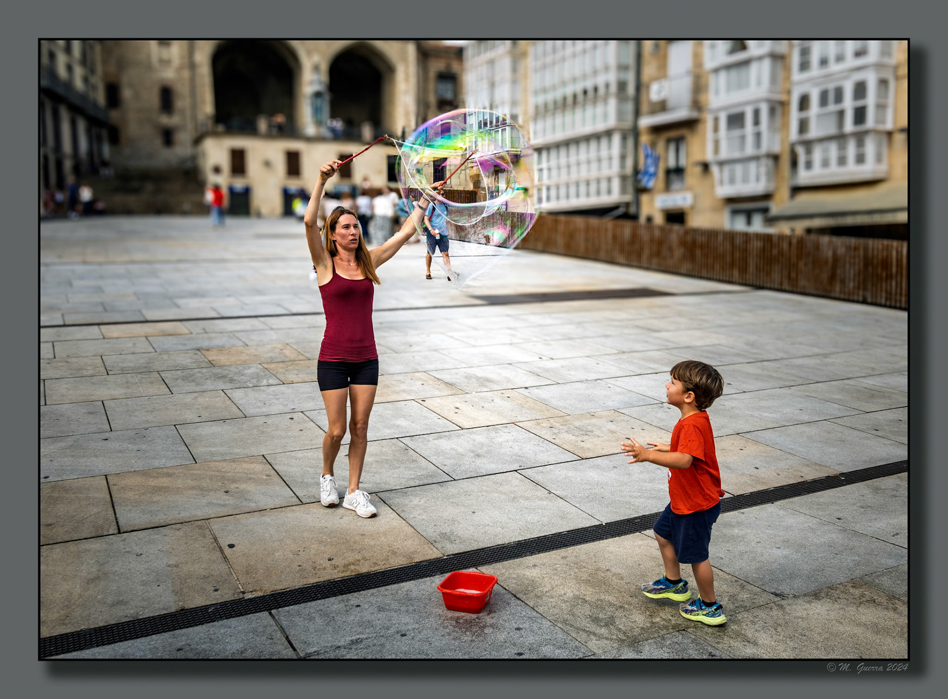 Mujer con su hijo haciendo pompas de jabón en la Plaza de la Virgen Blanca en Vitoria
