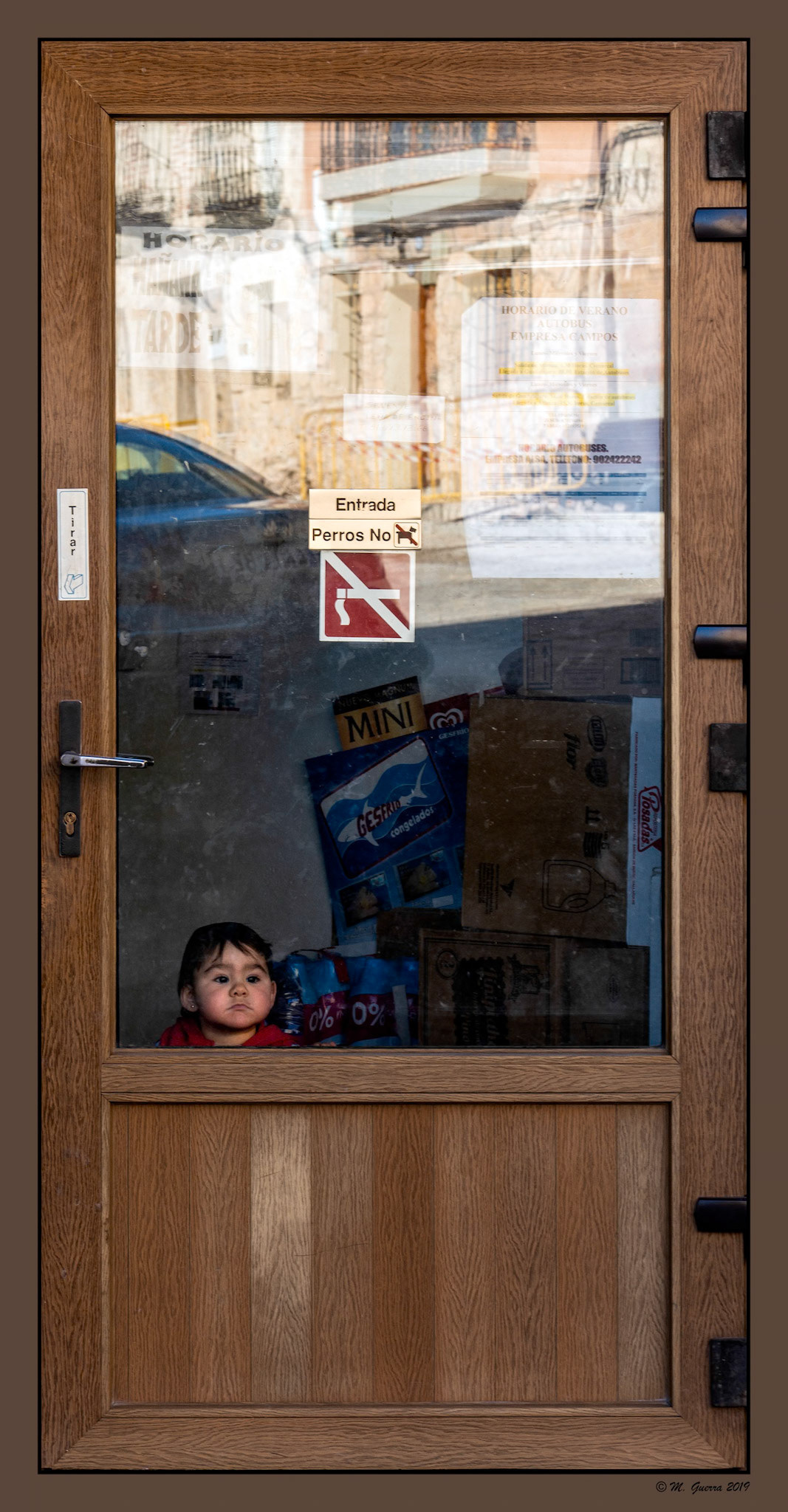 Niño sudamericano en una puerta de una tienda de Atienza. Ampliar. 100ASA