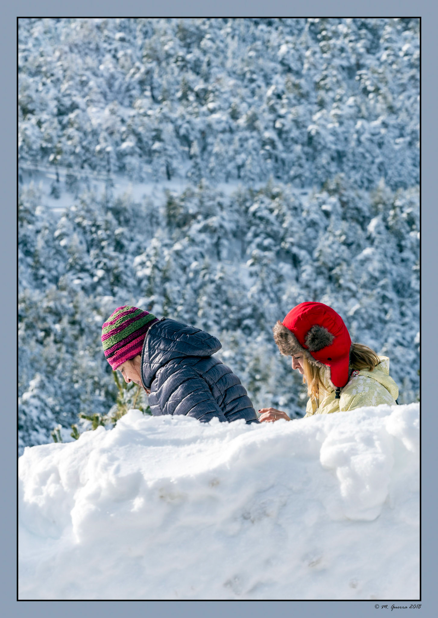 Dos chicas detrás de una pared de nieve en Navacerrada. Ampliar