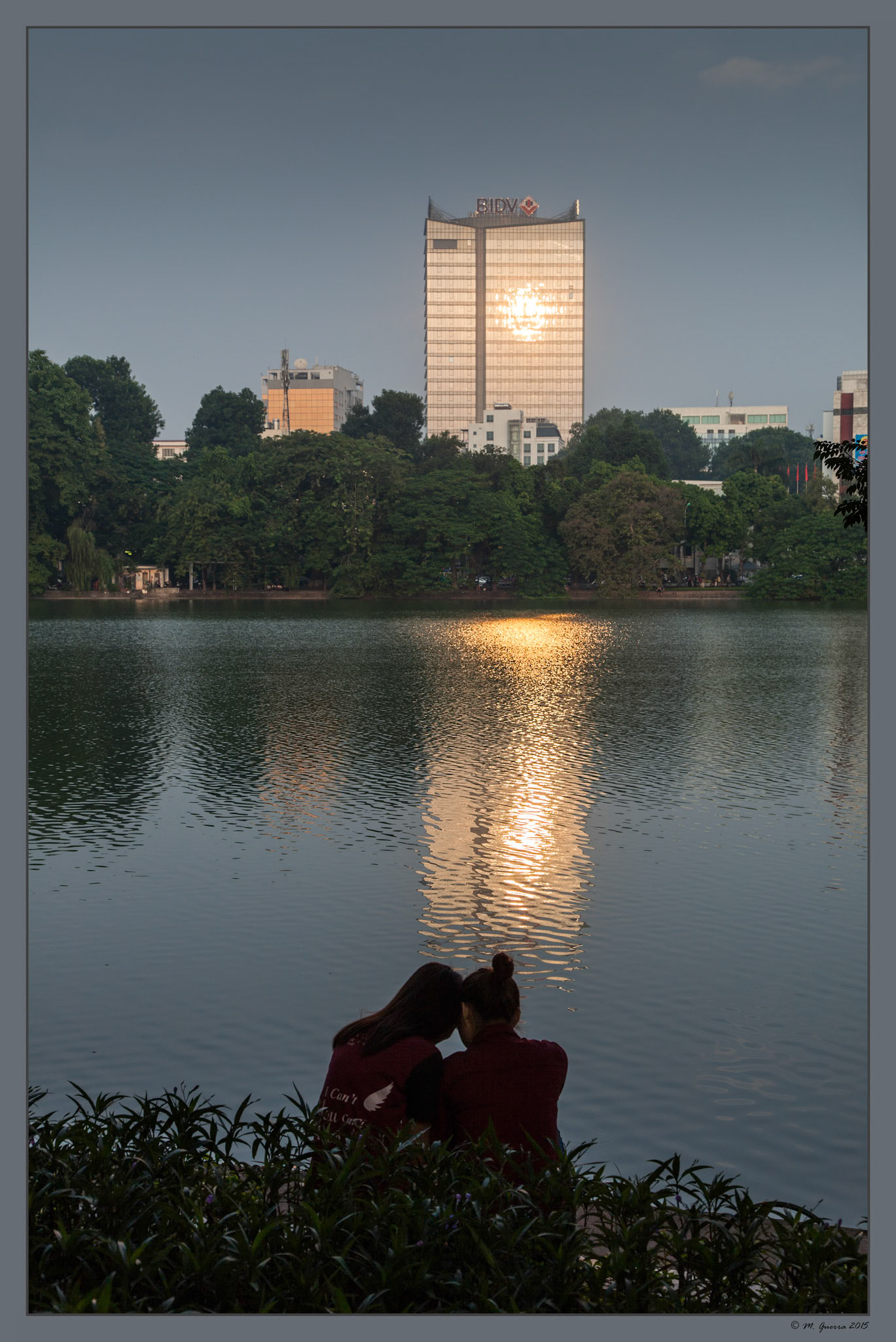 Pareja en un atardecer en el lago de Hanoi. Ampliar