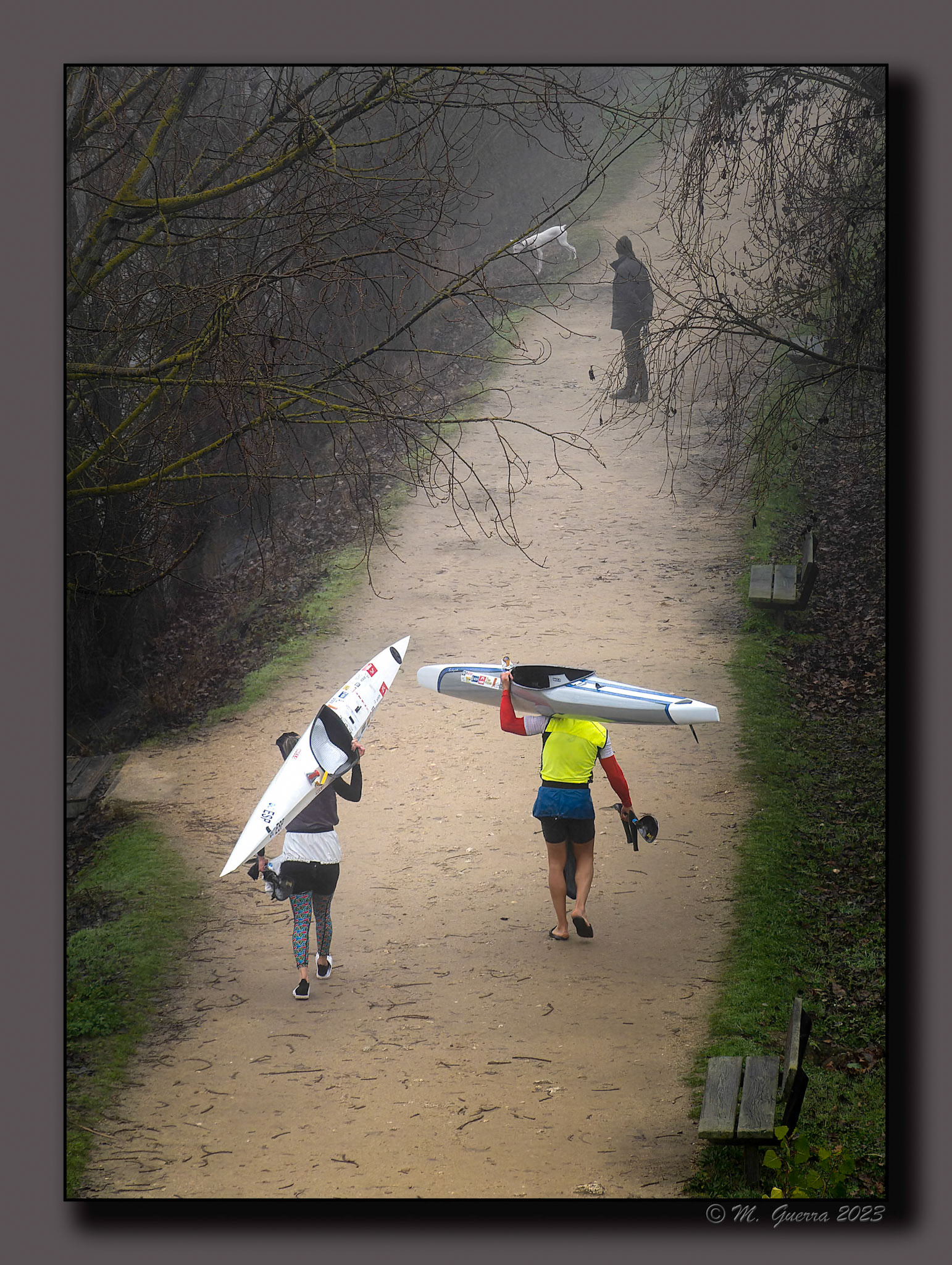 Dos piragüistas cargando sus canoas en un paseo en el margen del río Duero en Zamora un día de niebla. 100ASA
