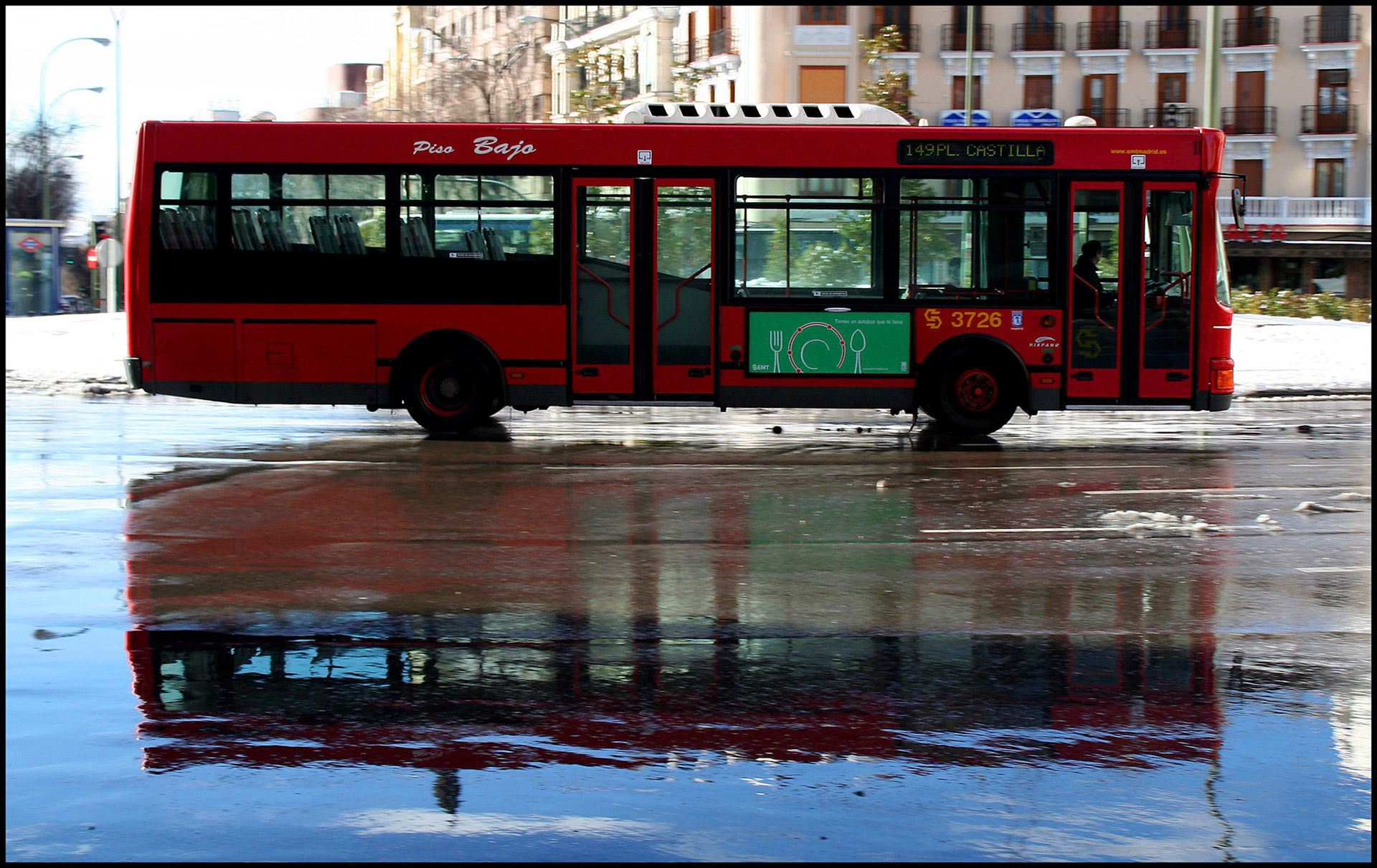 Autobús en La plaza de Cuatro Caminos nevada en Madrid. Ampliar