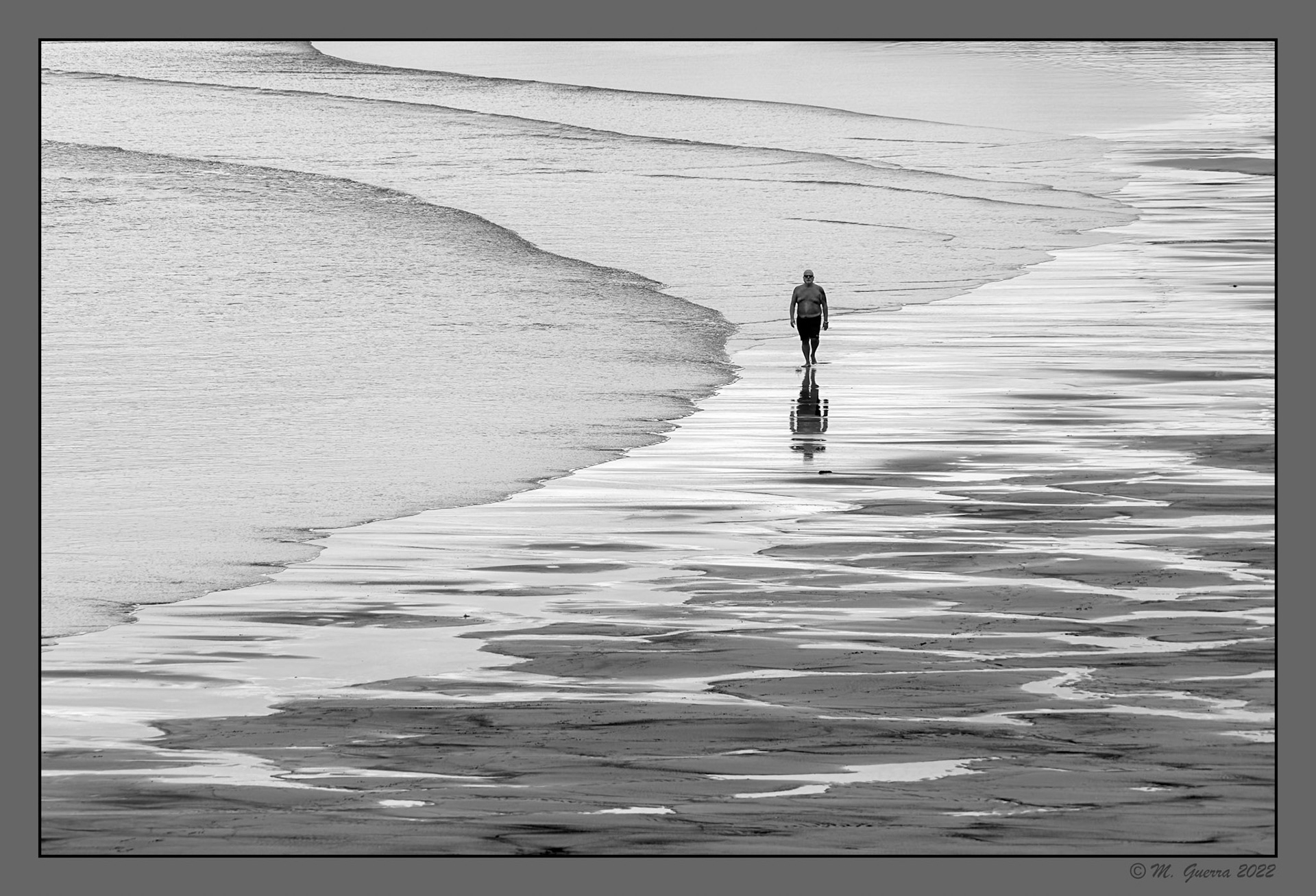 Personas paseando por la playa de Avilés con marea baja. 100ASA