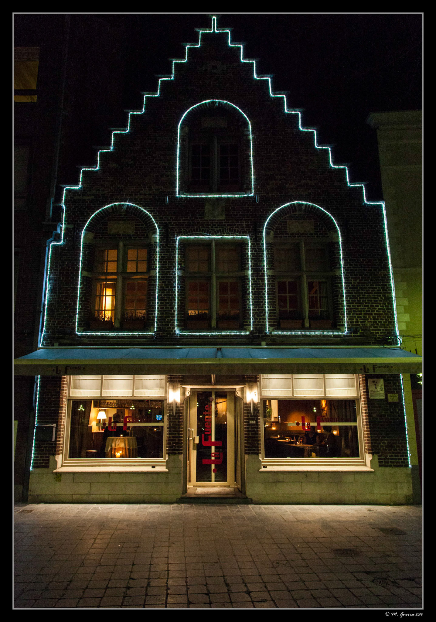 Casa antigua silueteada con luz en Brujas. Ampliar