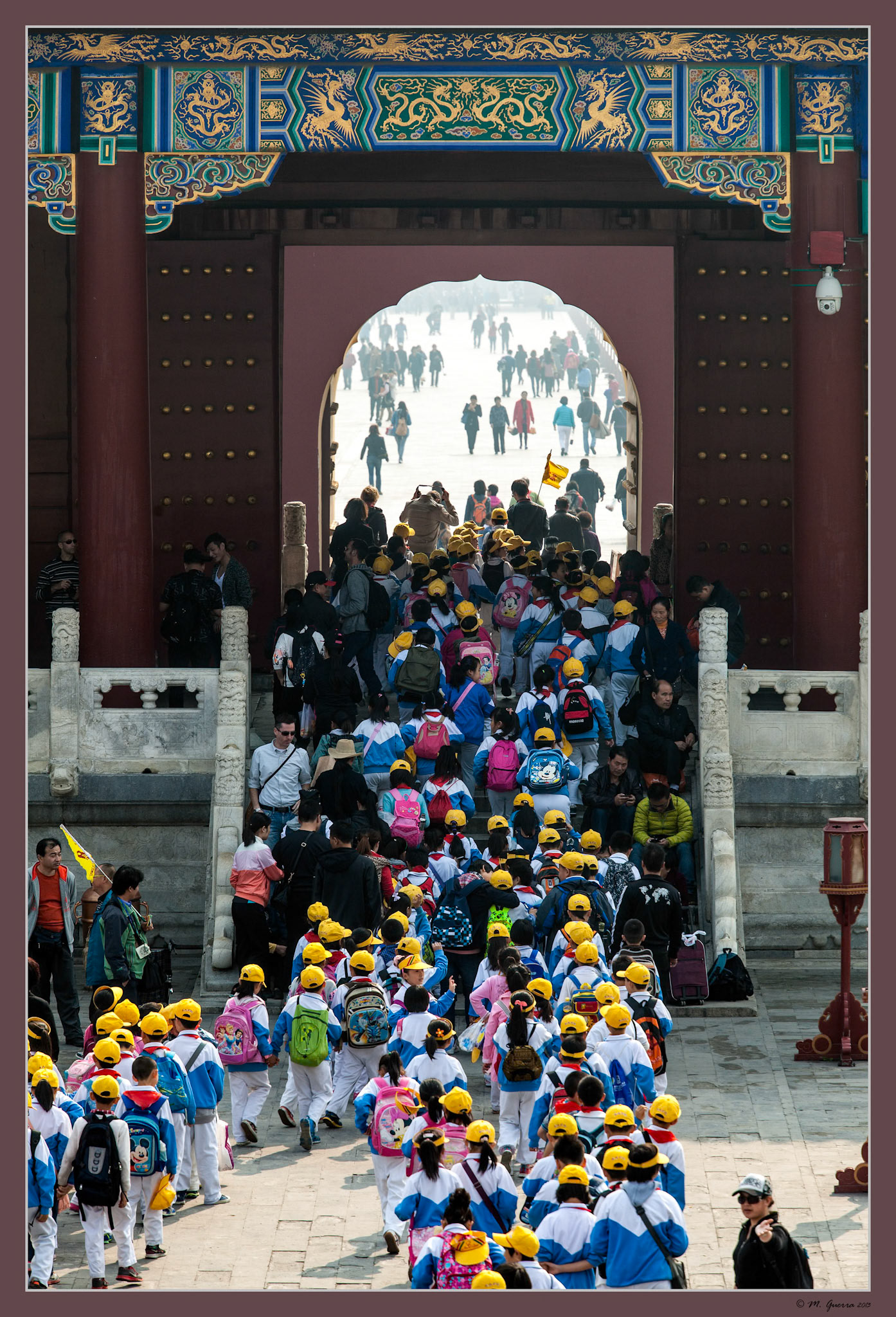 Grupo de niños con gorras amarillas visitando el Templo del Cielo de Beijing. Ampliar