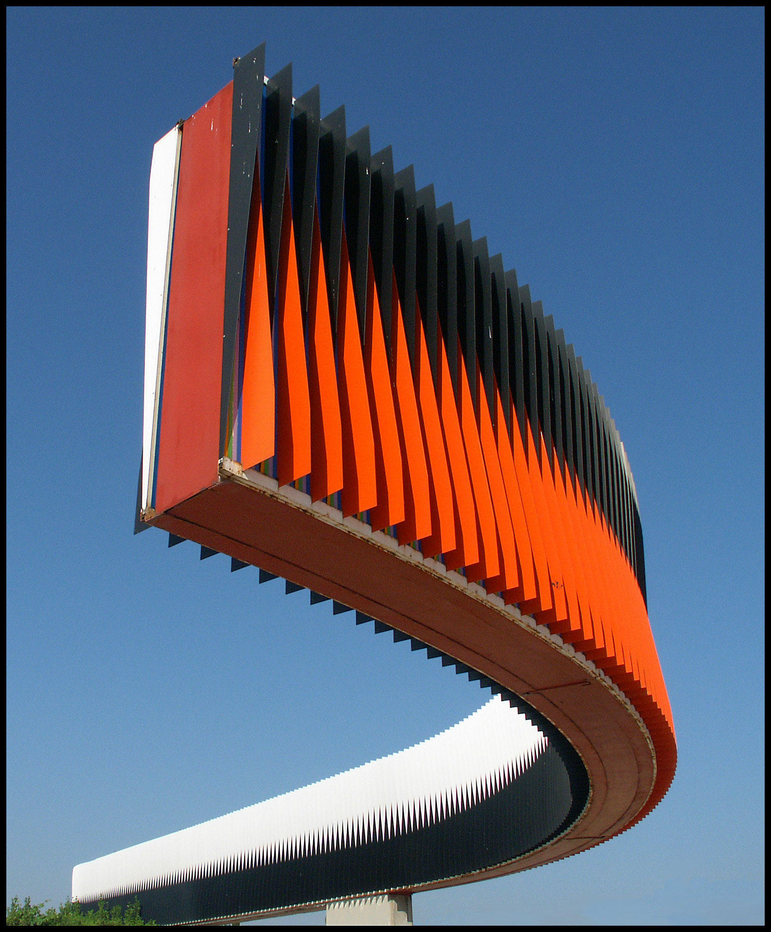 Escultura de hierro rojo, blanco y negro en el parque de Juan Carlos I de Madrid. Ampliar