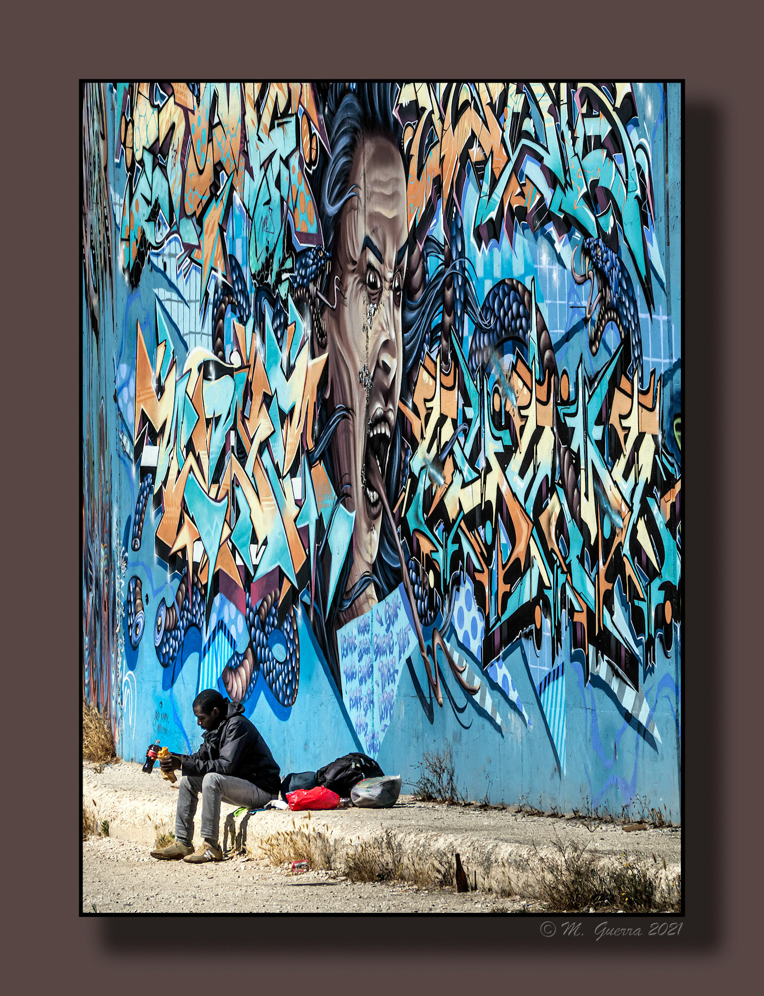 Negro sentado al lado de una pintada artística