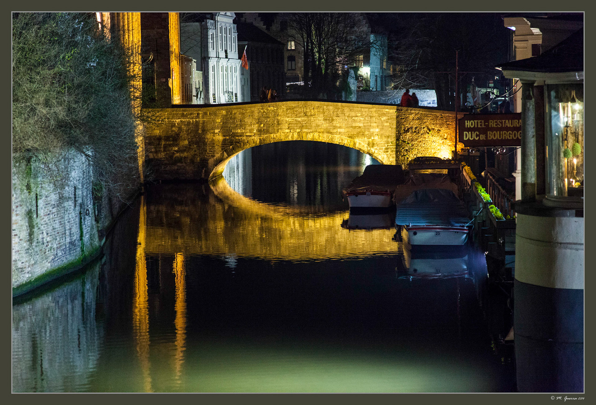 Puente iluminado sobre un canal de Brujas. Ampliar