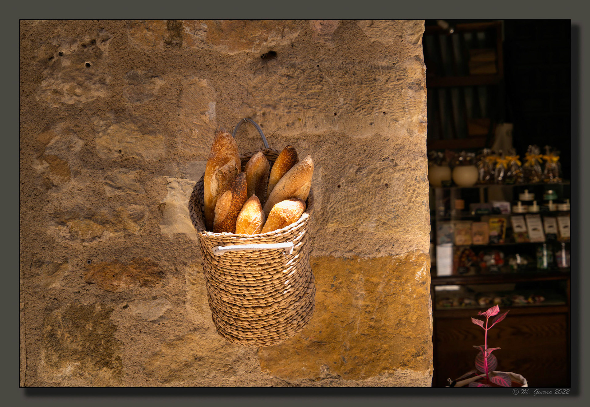 Cesta con panes en una pared de una tienda en Pedraza