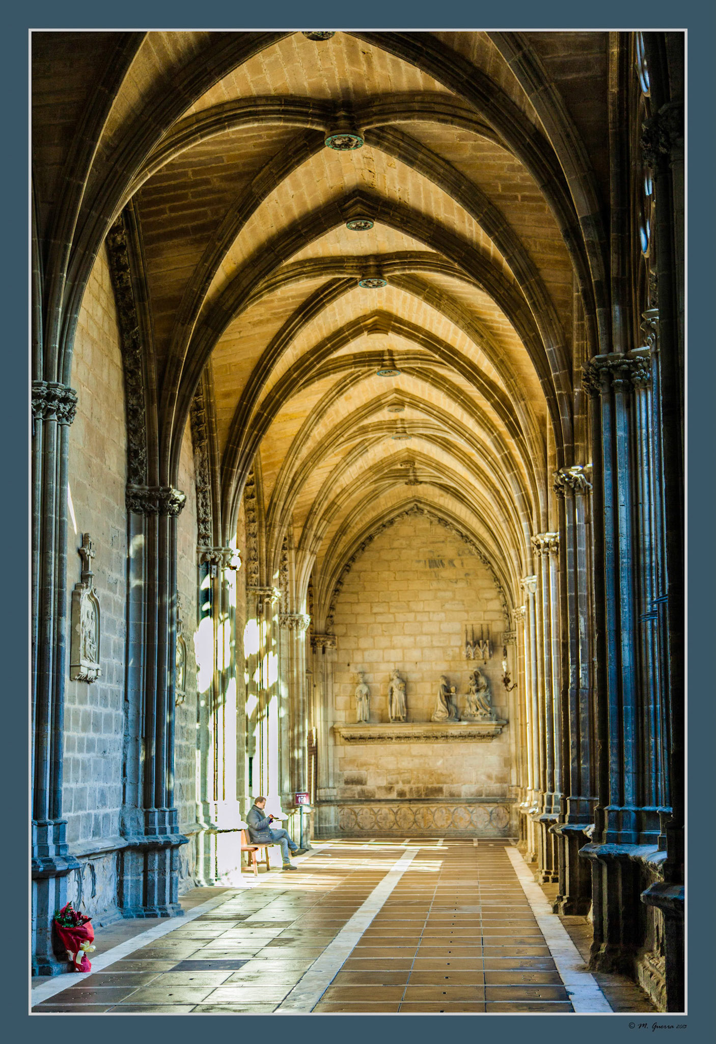 Un hombre sentado en un banco del claustro de la Catedral de Pamplona. Ampliar