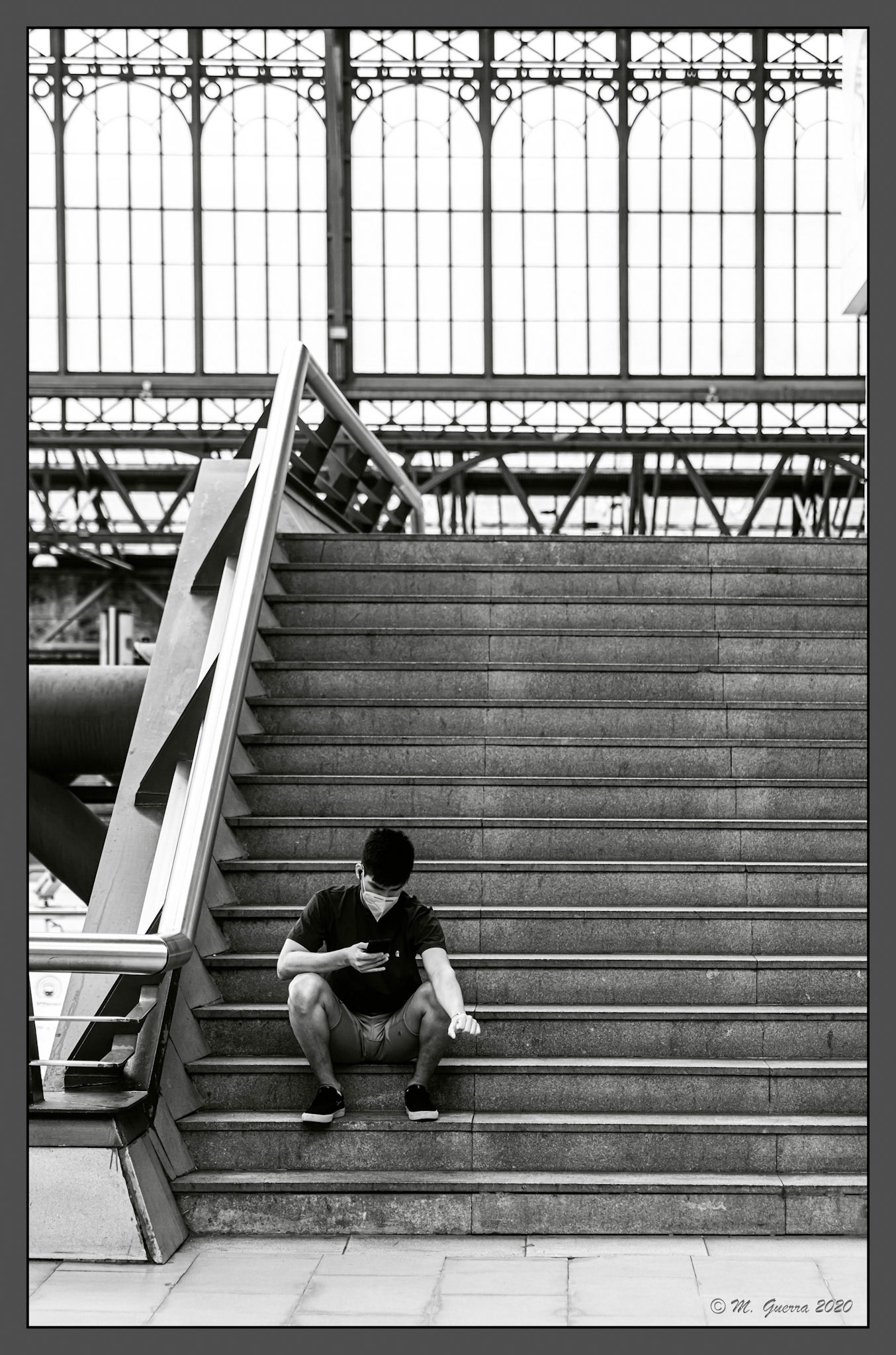 Chico en unas escaleras en Príncipe Pío. Ampliar